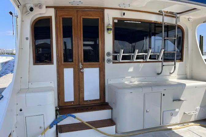 1989 Topaz 44 Sportfisherman boat deck with wooden doors and fishing rod holders.