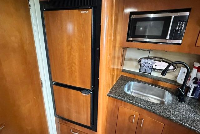 Kitchen area in a 2004 Carver 360 Mariner with fridge, microwave, and sink.