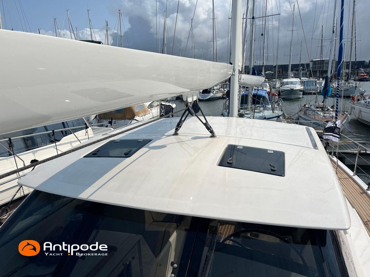 Amel 64 yacht from 2010 docked at a marina, showcasing sleek design and modern features.