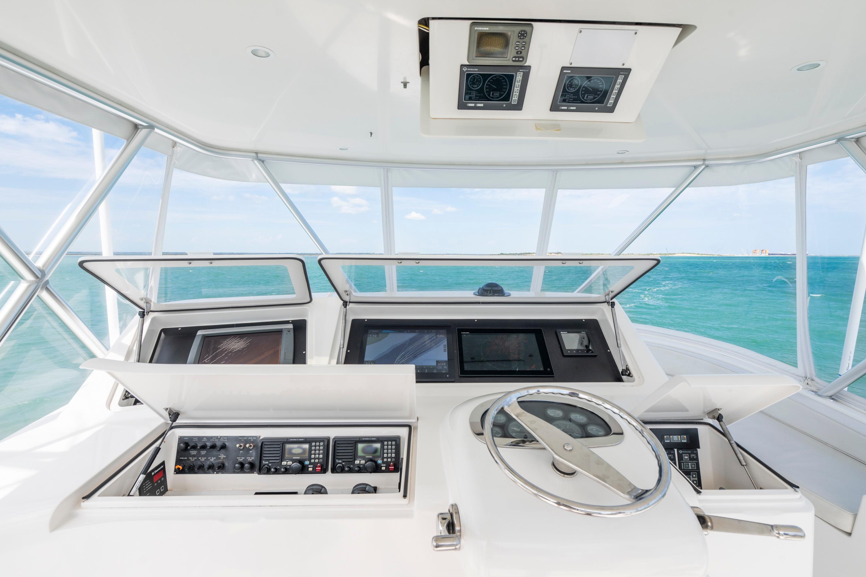 Helm of 2009 Viking 50 Convertible yacht with ocean view, featuring advanced navigation controls.