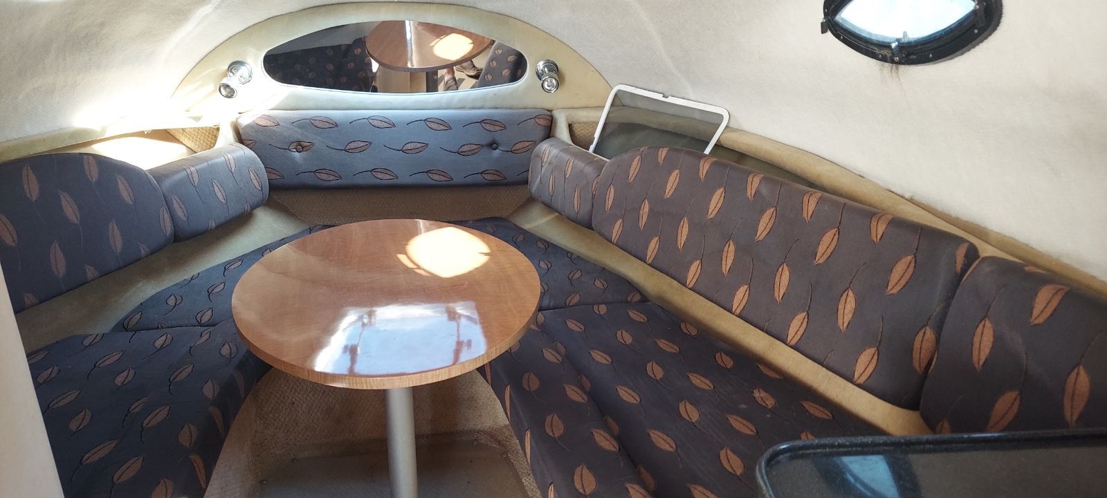 Interior of 2004 Regal Commodore 2465 boat with cushioned seating and table.