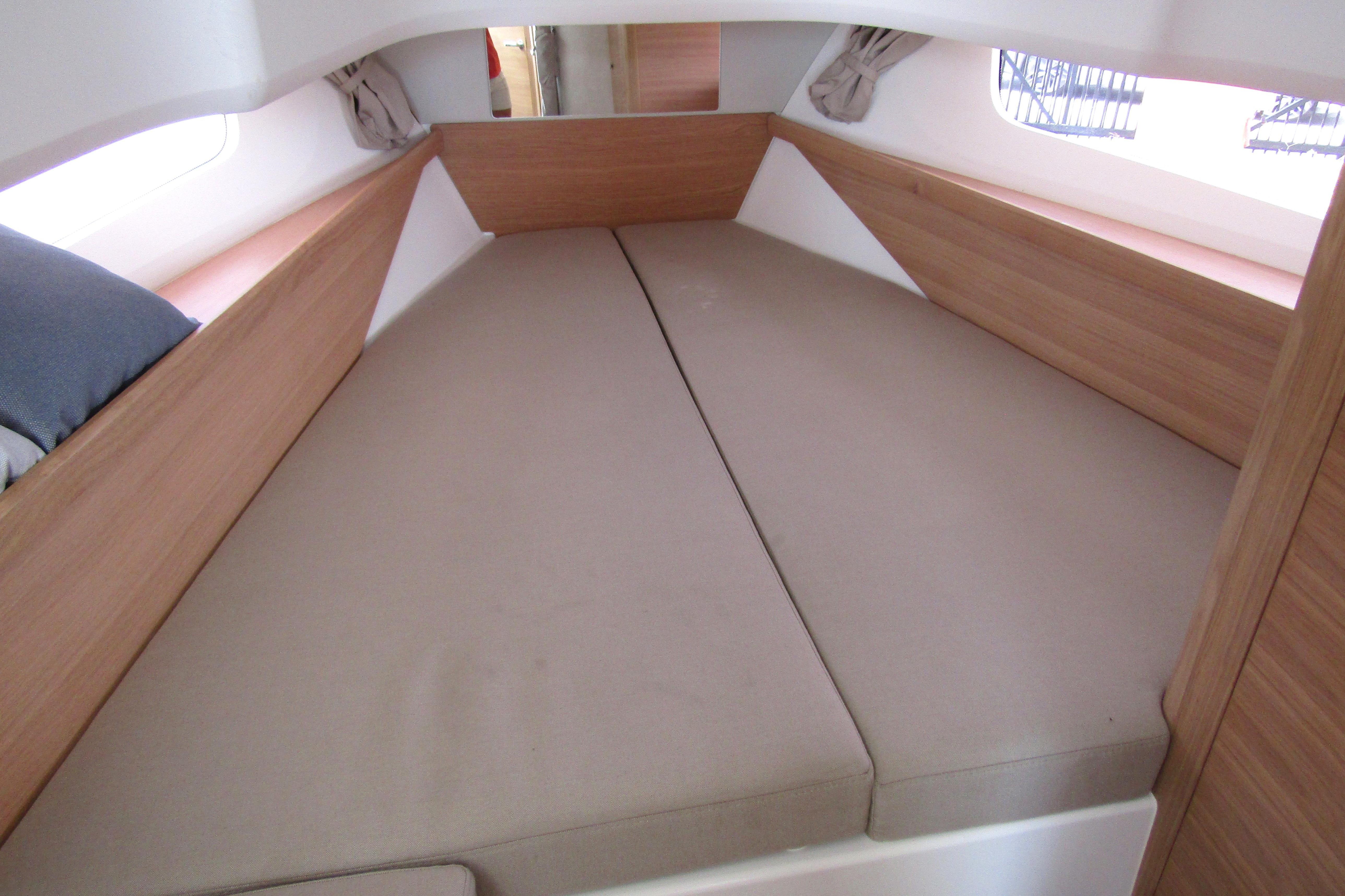 Cozy interior cabin of 2025 Nimbus Tender 11 with beige cushions and wooden accents.
