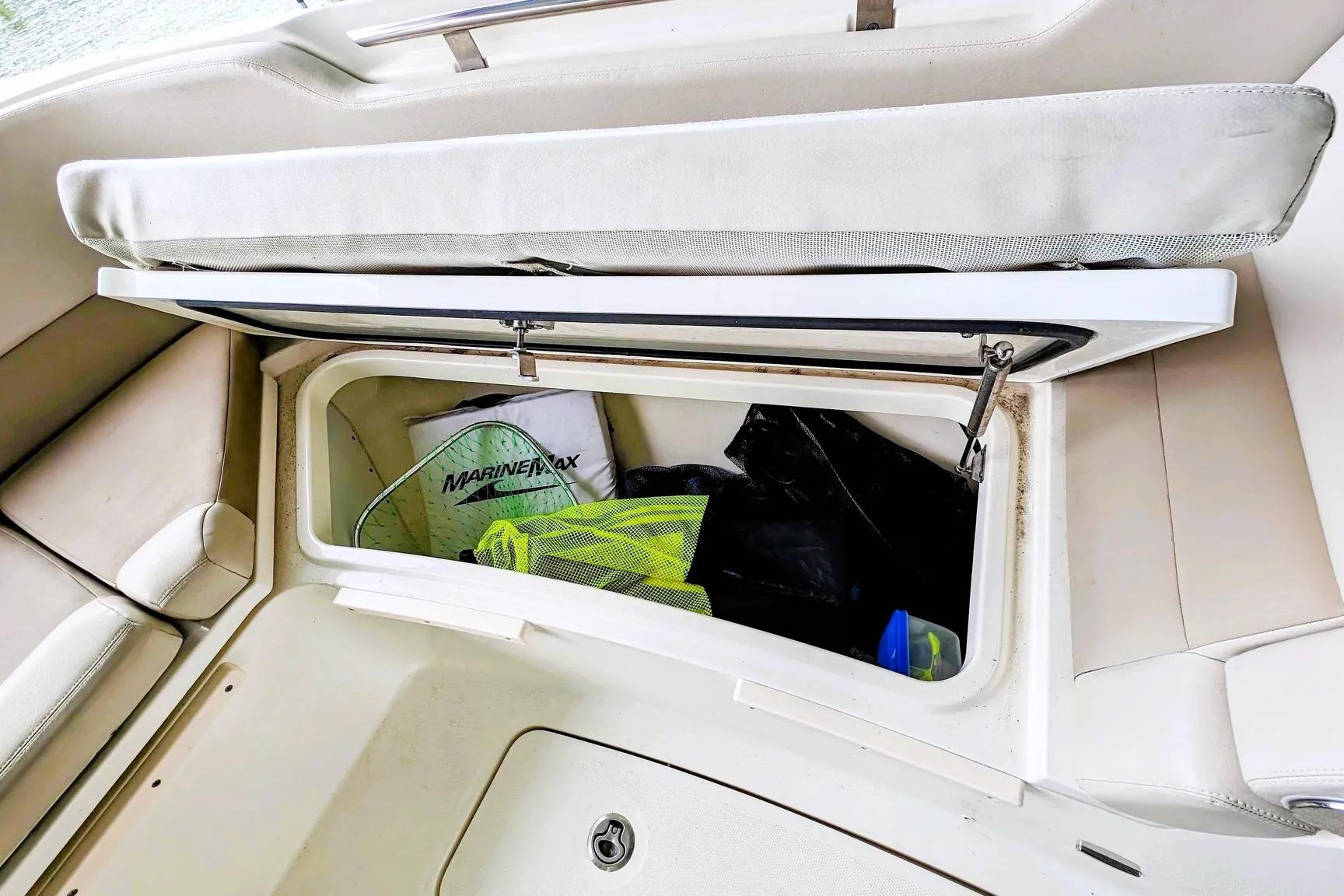 Open storage compartment on 2017 Boston Whaler 320 Vantage boat with gear inside.