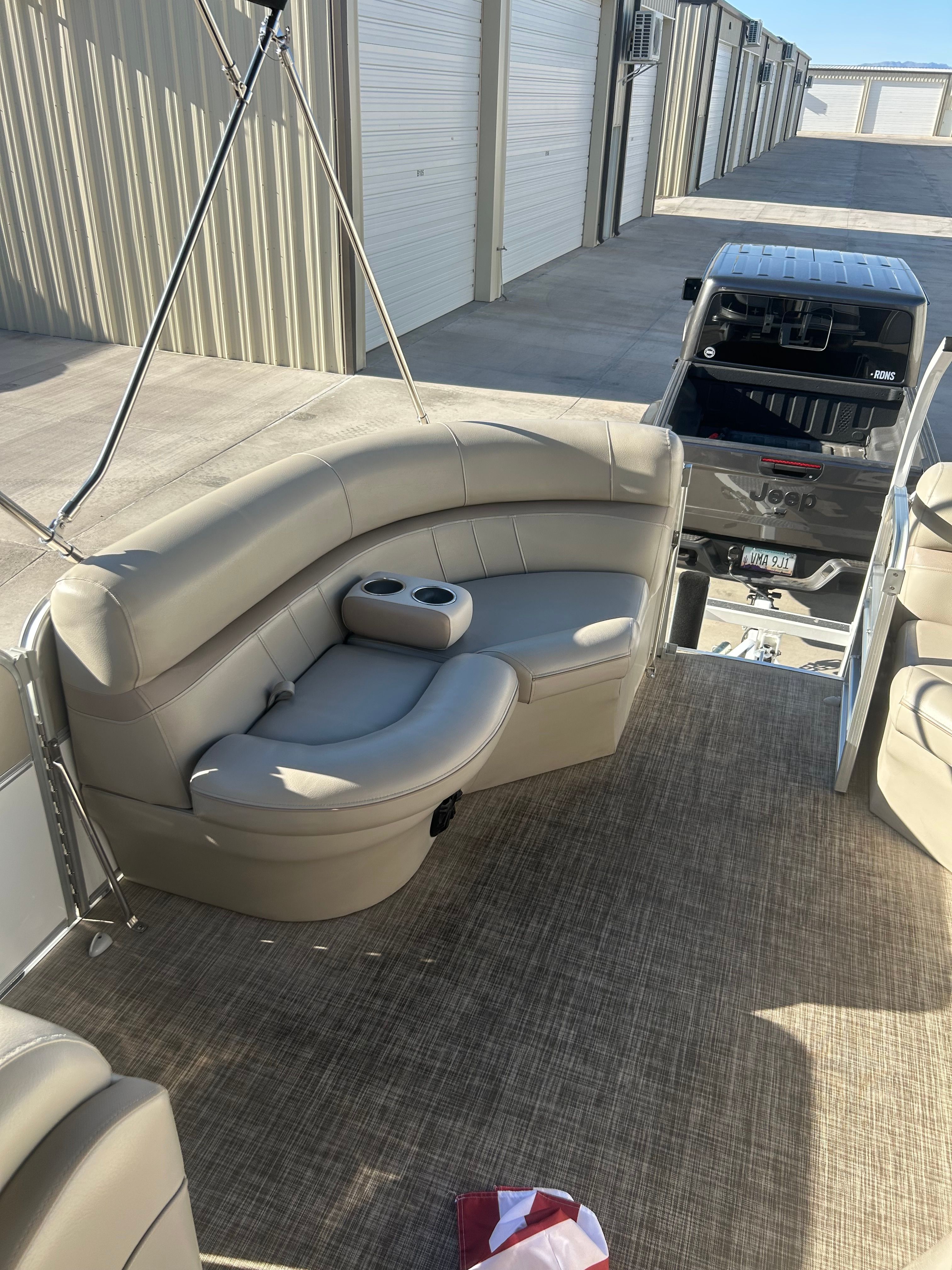 A 2018 Berkshire 24RFX CTS pontoon boat with beige seating and textured flooring.