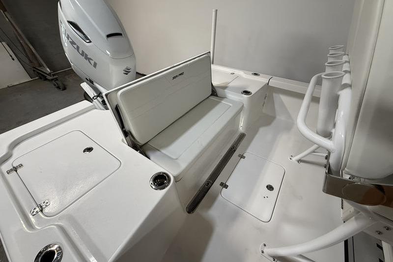 2026 Sea Pro 250 Bay boat interior with Suzuki engine and seating area.