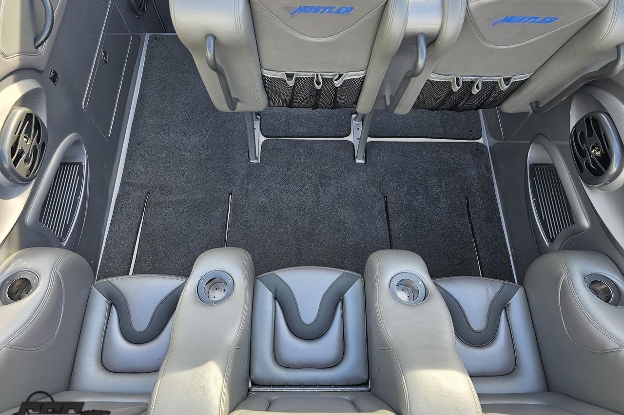 Interior of a 2007 Hustler 41 Razor boat with gray seating and cup holders.