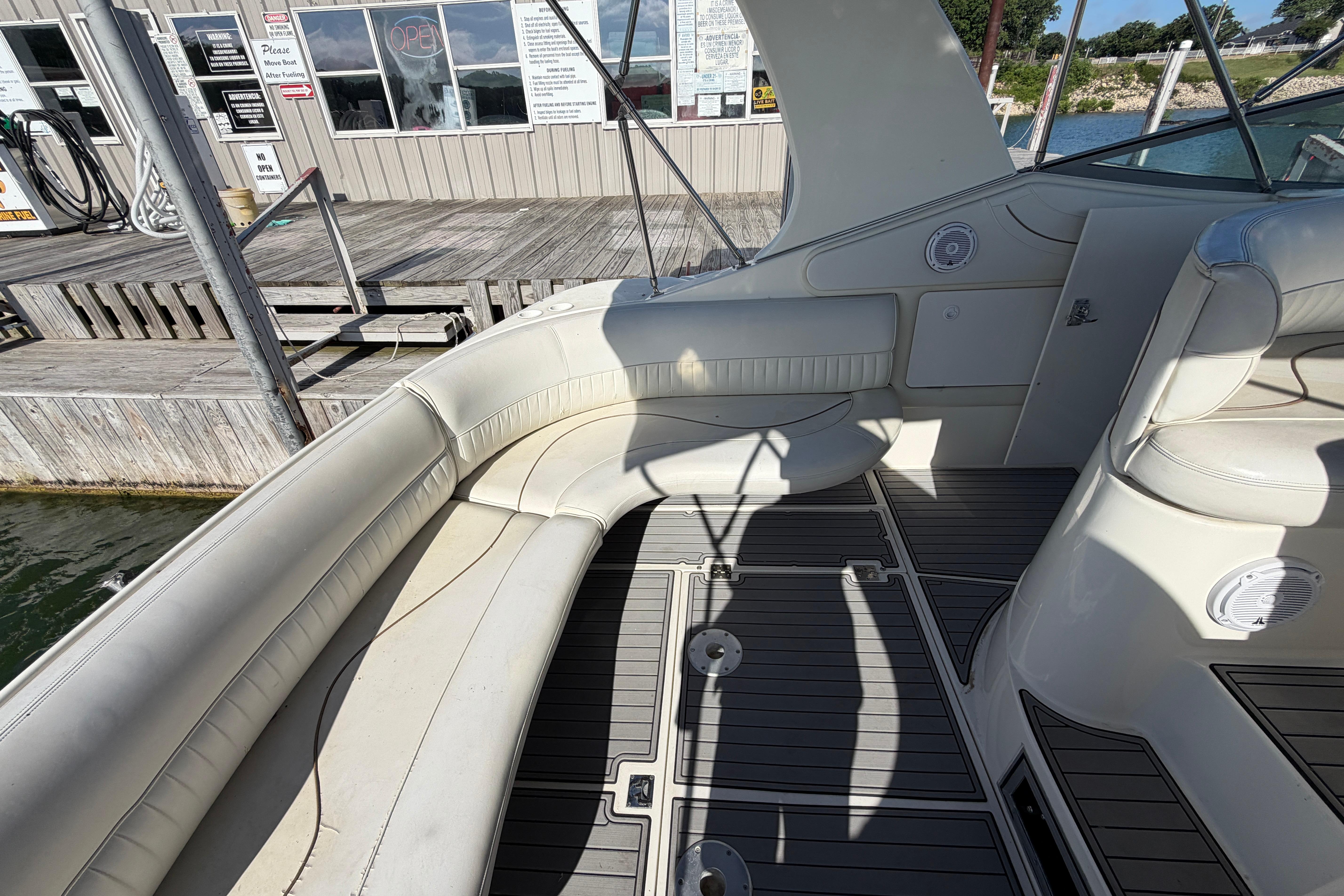 1997 Cruisers 3575 boat interior with white seating and wooden dock background.