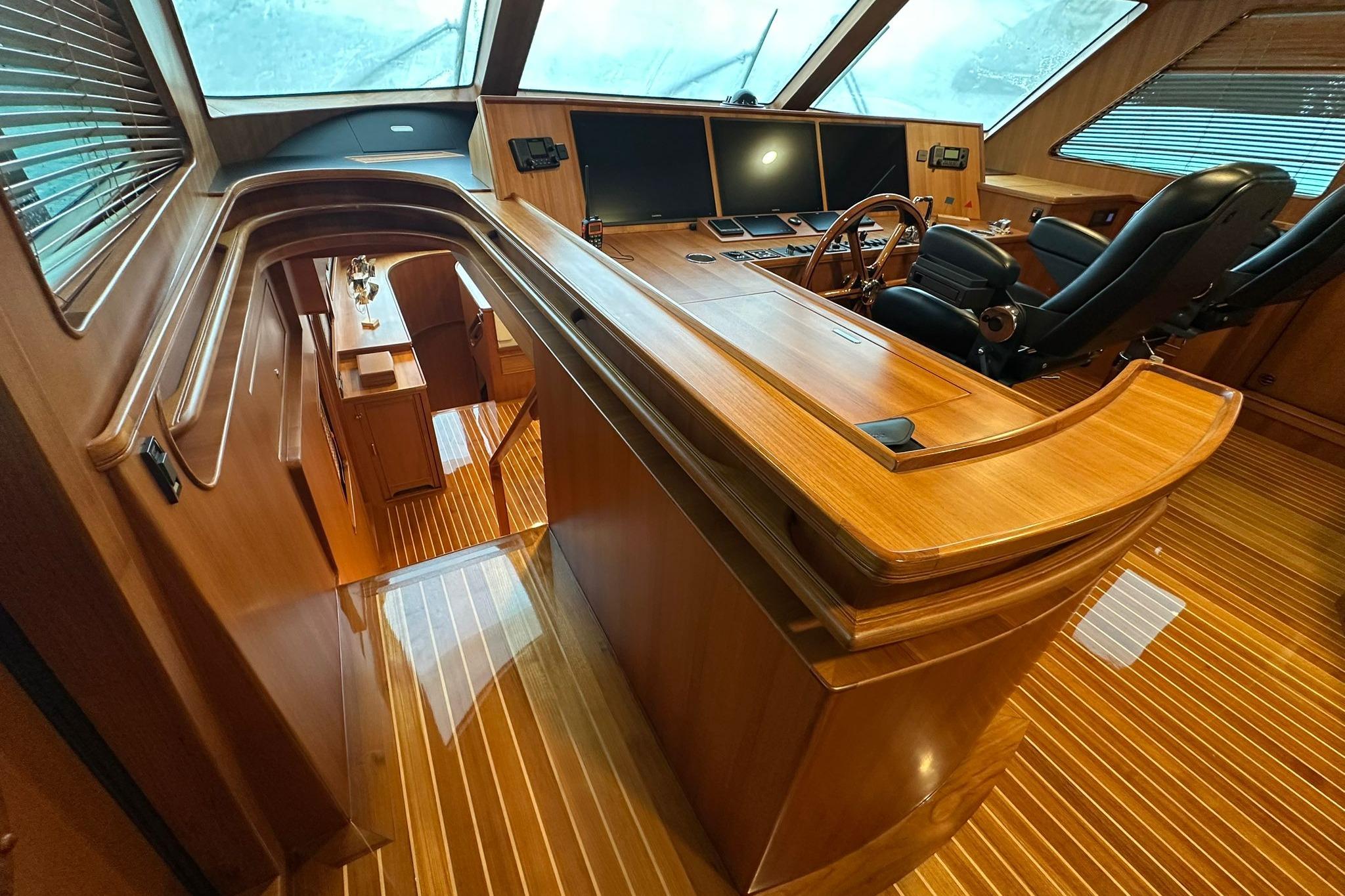 Luxurious interior of 2023 Marlow Explorer 66E-CB yacht with wooden finishes and modern controls.
