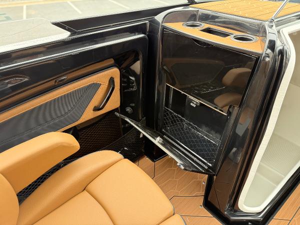 2025 Yamaha Boats 255XD interior with tan seating and sleek black storage compartment.