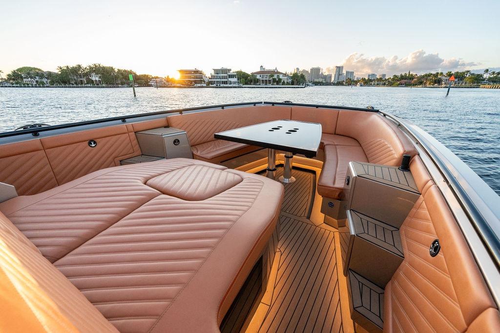 Luxurious DeKoning 43 yacht interior with elegant seating and table, 2023 model, sunset view.