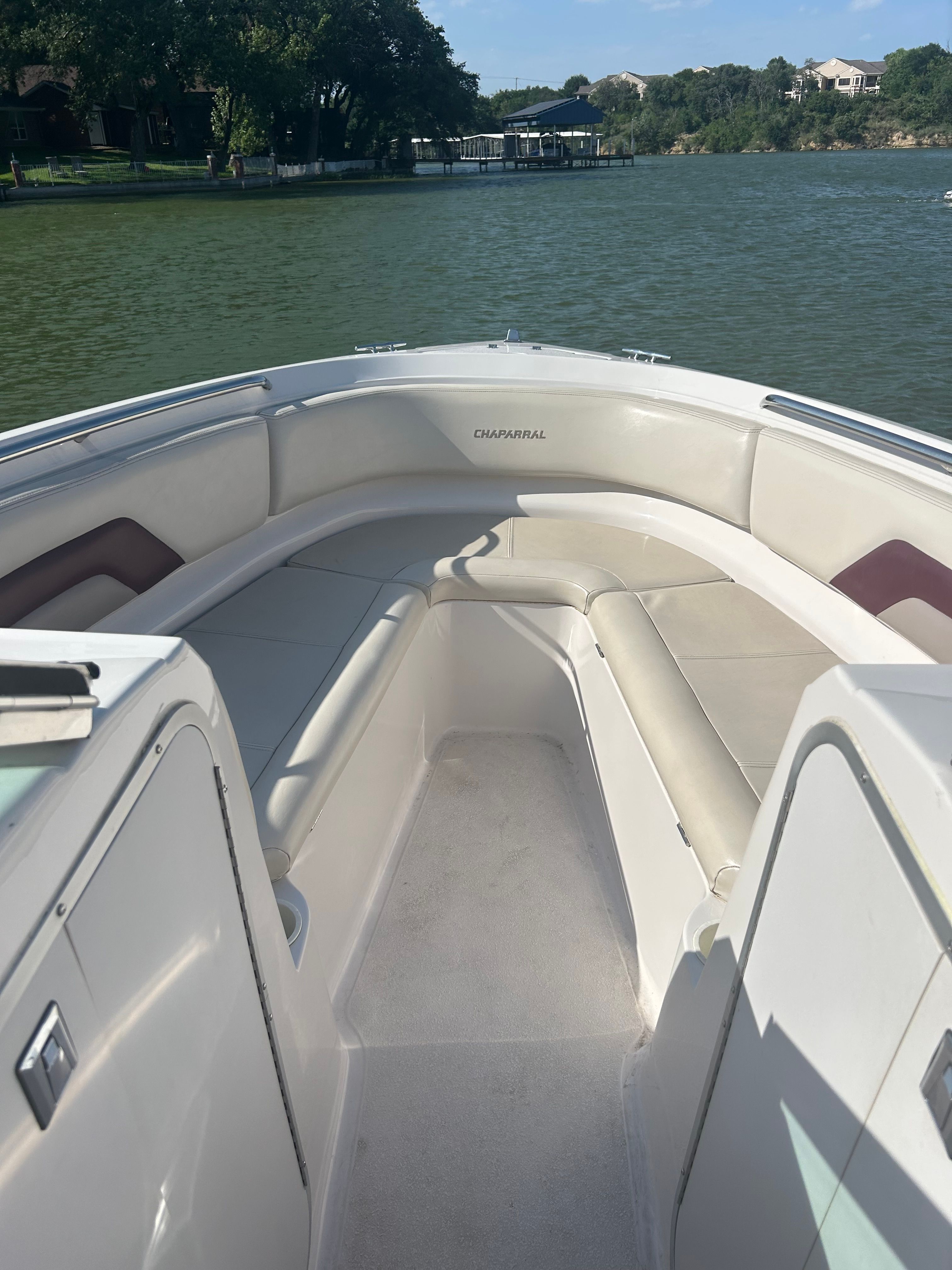 The image shows the bow seating area of a 1995 Chaparral 2330 boat on a lake.