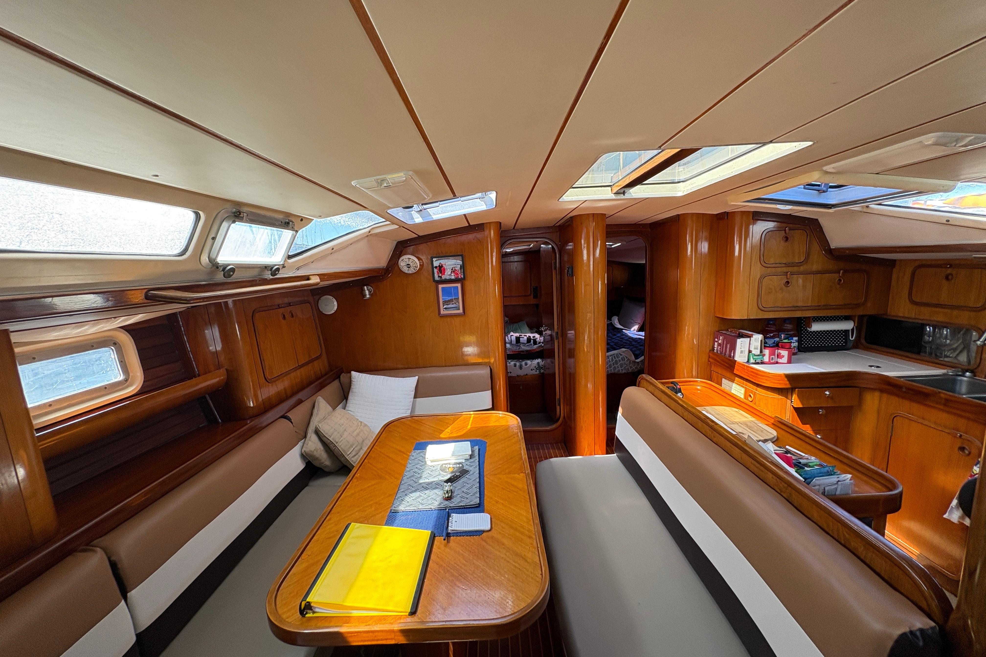 Interior of 1990 Beneteau Oceanis 500 sailboat with wood finish and cozy seating area.