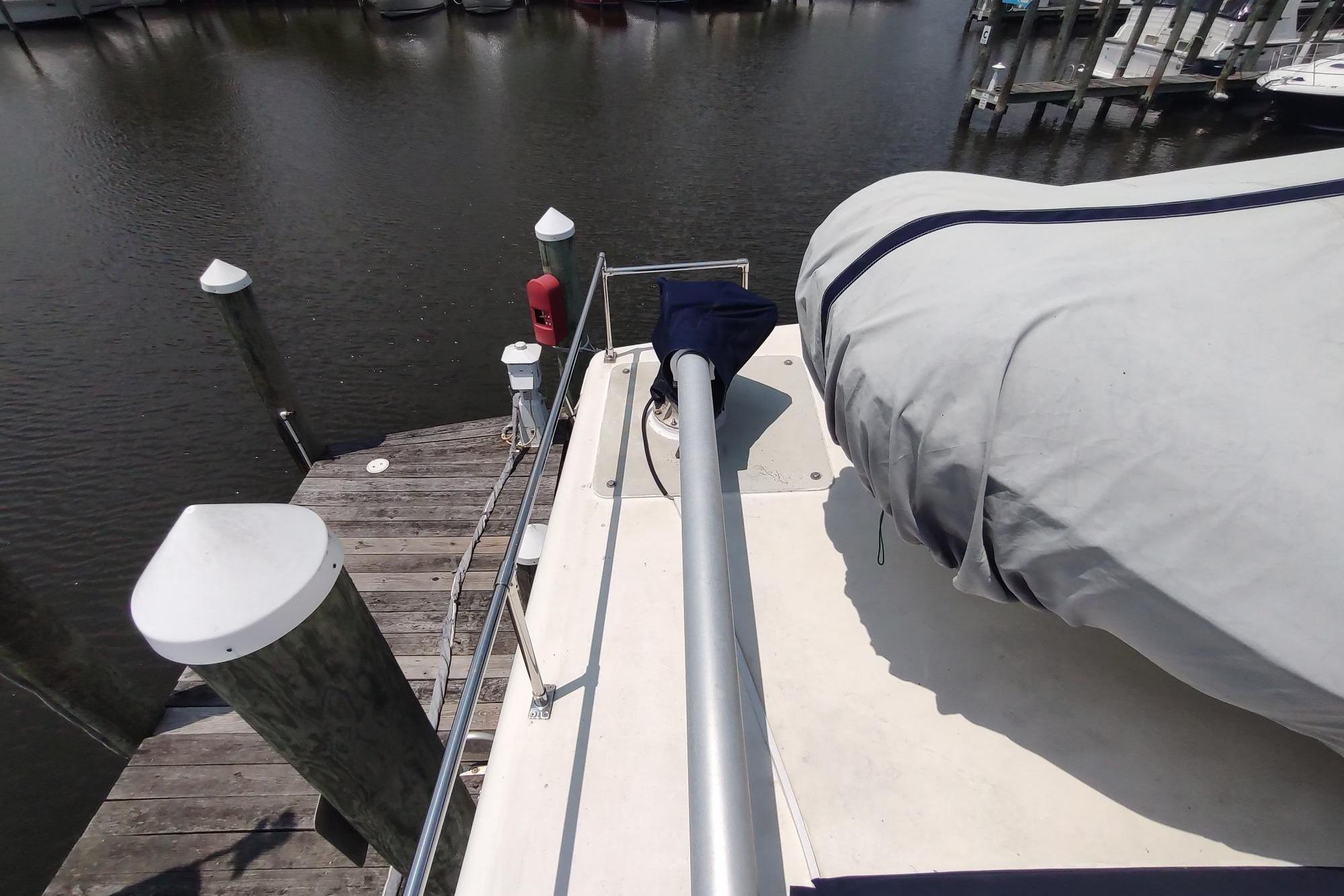 1989 Hyatt Double Cabin Motoryacht docked at marina, covered deck, calm water.