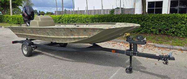 2025 Tracker Grizzly 1648 SC boat on trailer in parking lot.