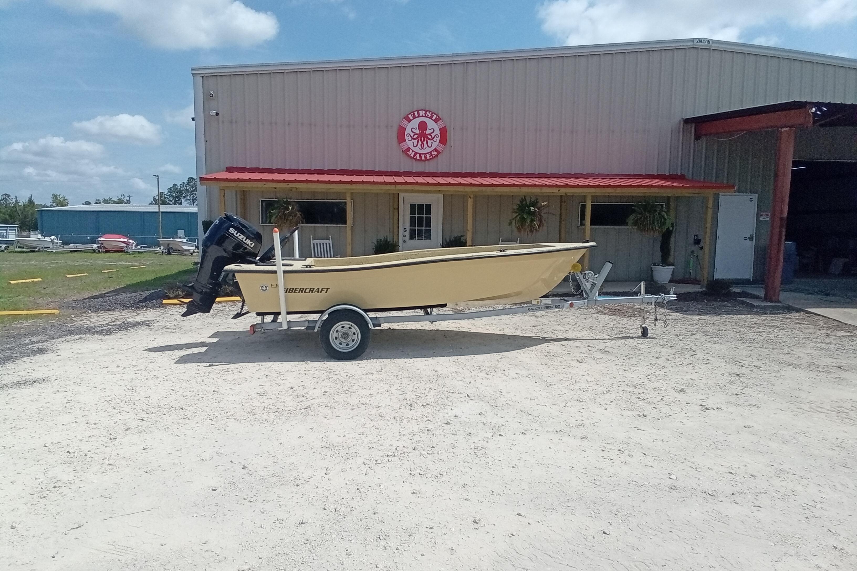 2025 Fibercraft F16 boat on trailer outside a building with red roof.