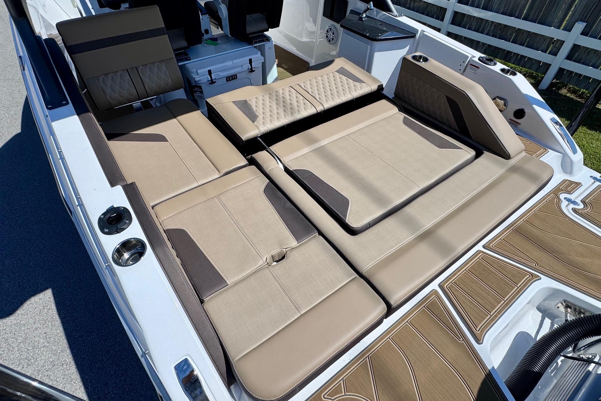 2026 Monterey Elite 27 OB boat interior with beige seating and wood-patterned flooring.