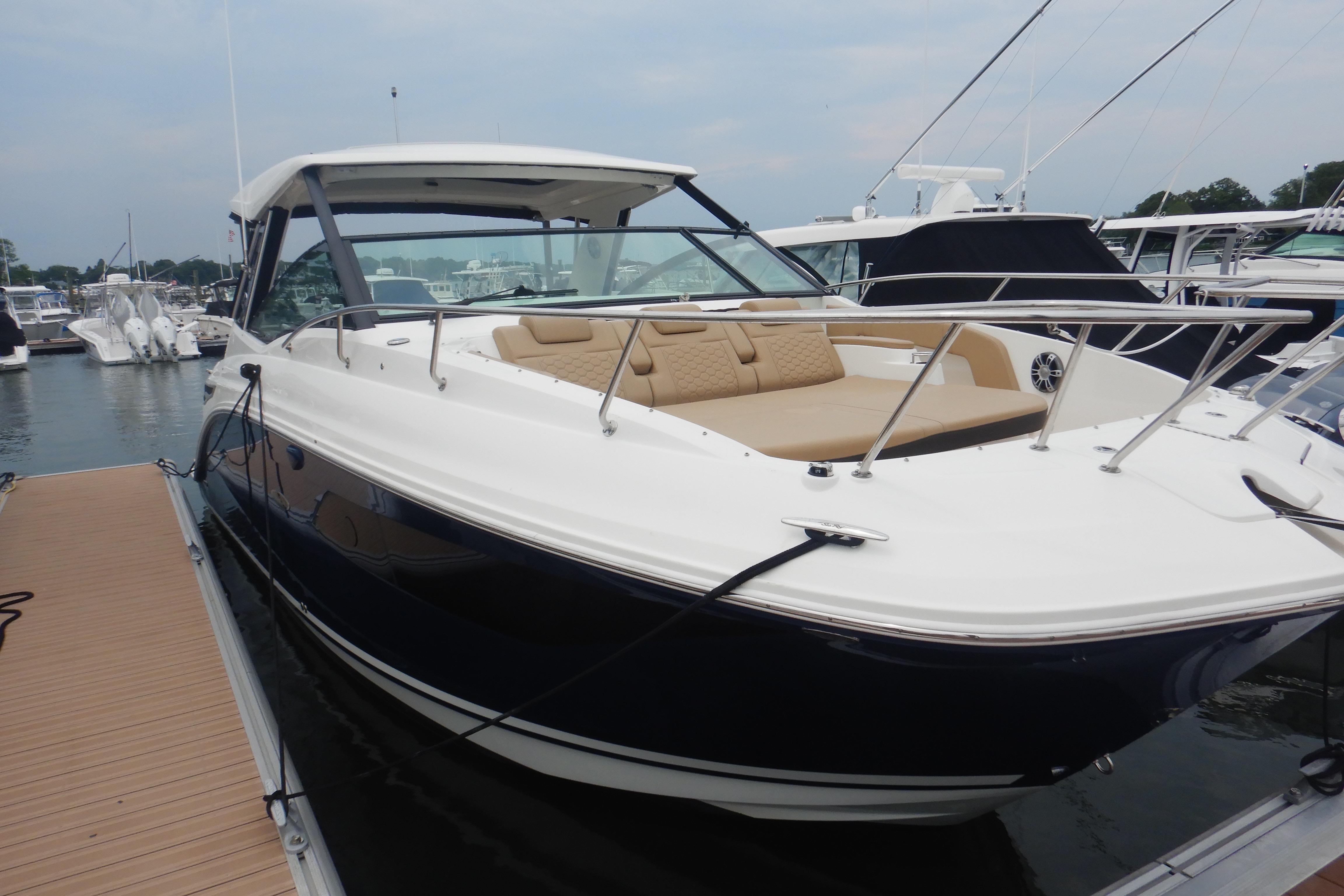 2023 Sea Ray Sundancer 320 docked at marina, showcasing sleek design and spacious deck.