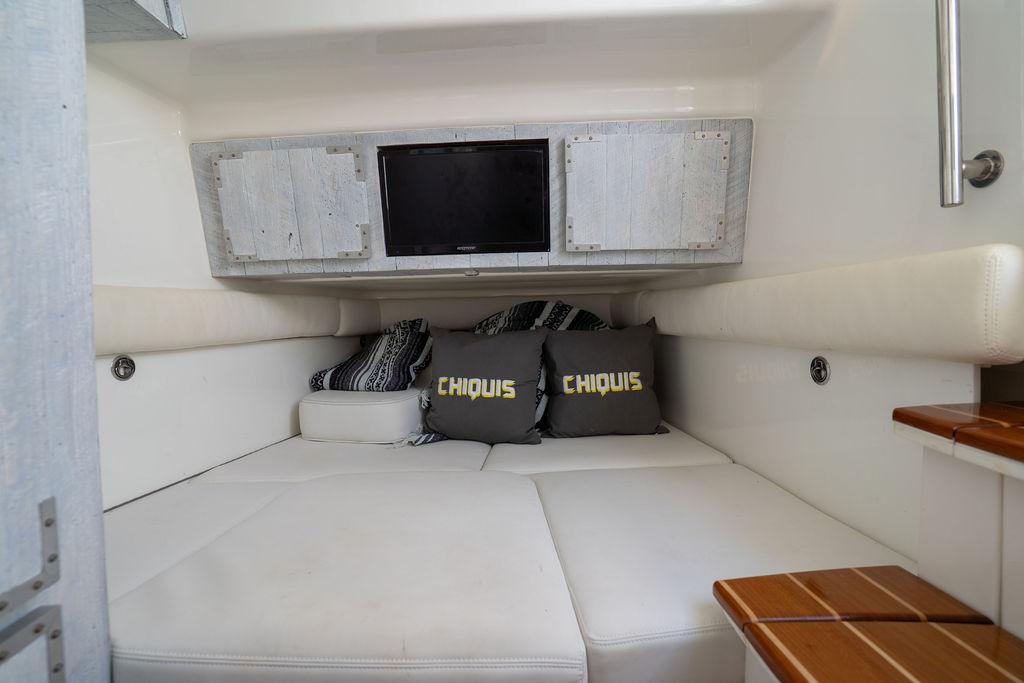 Luxurious cabin interior of 2019 HCB 53 boat with cozy seating and TV.