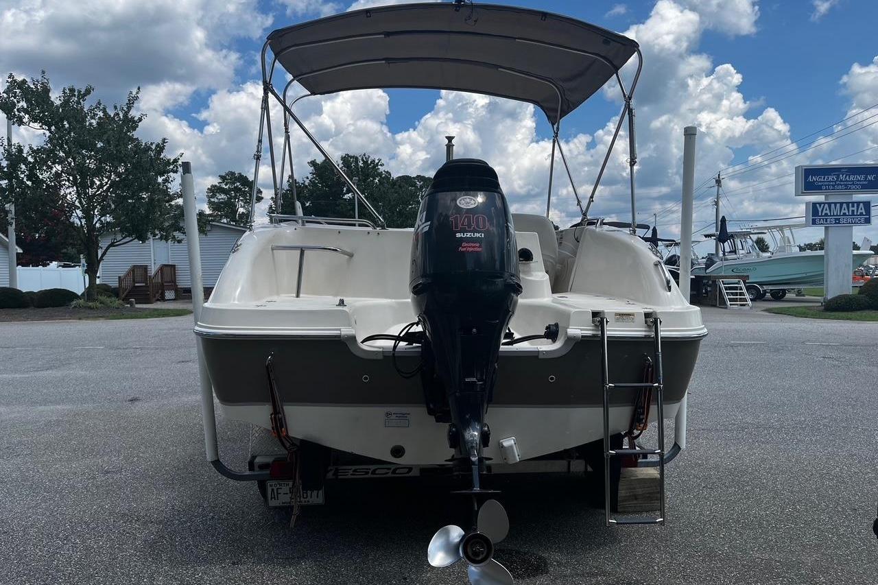2008 Hurricane FD202 boat with Suzuki 140 outboard motor, parked outdoors under cloudy sky.