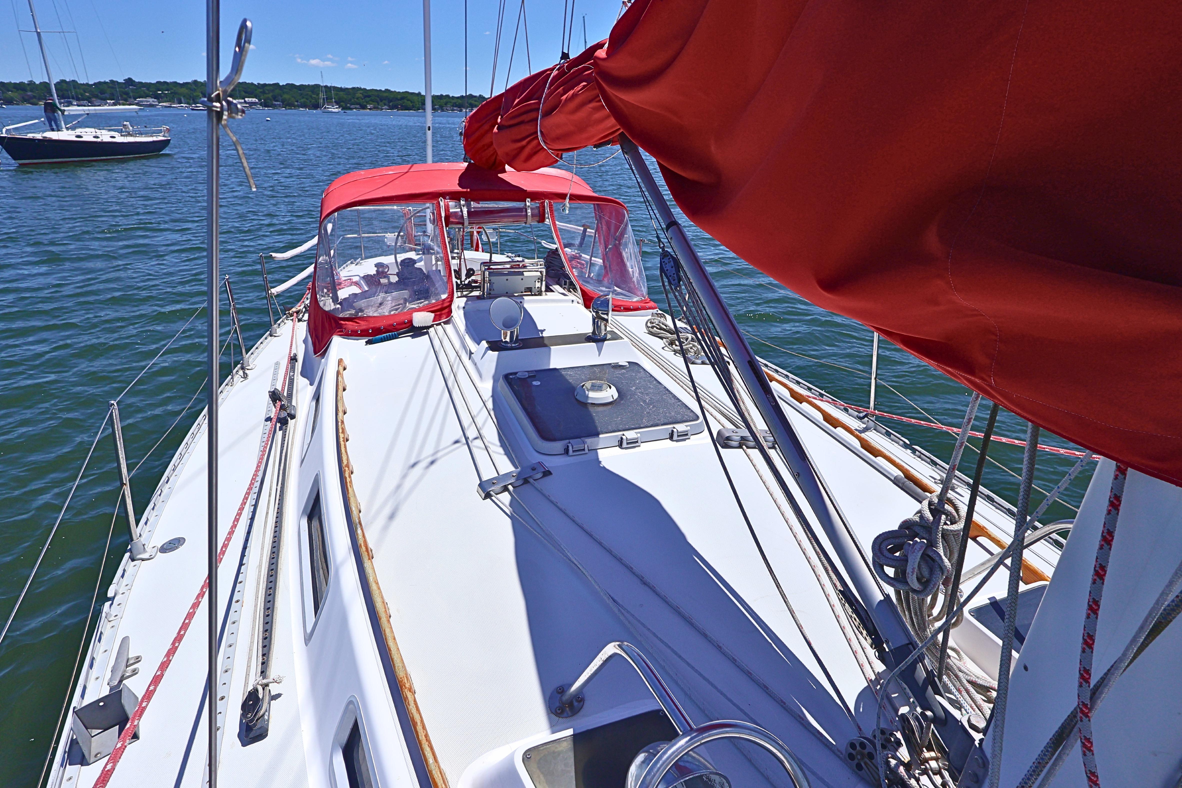 1989 J Boat J 40 sailboat with red canopy on calm water.