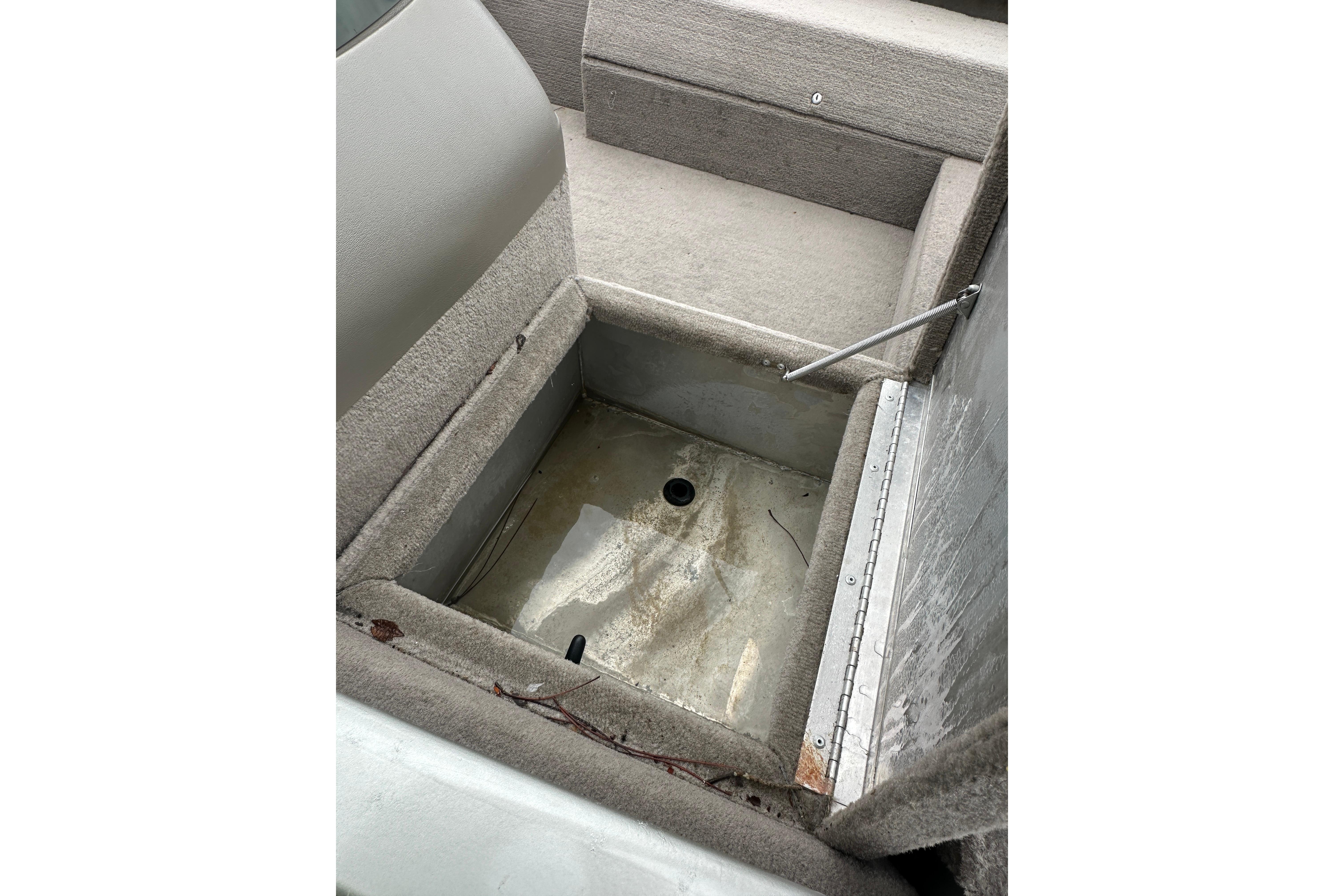 Open storage compartment in a 2002 Fisher 1710 boat, showing interior details.