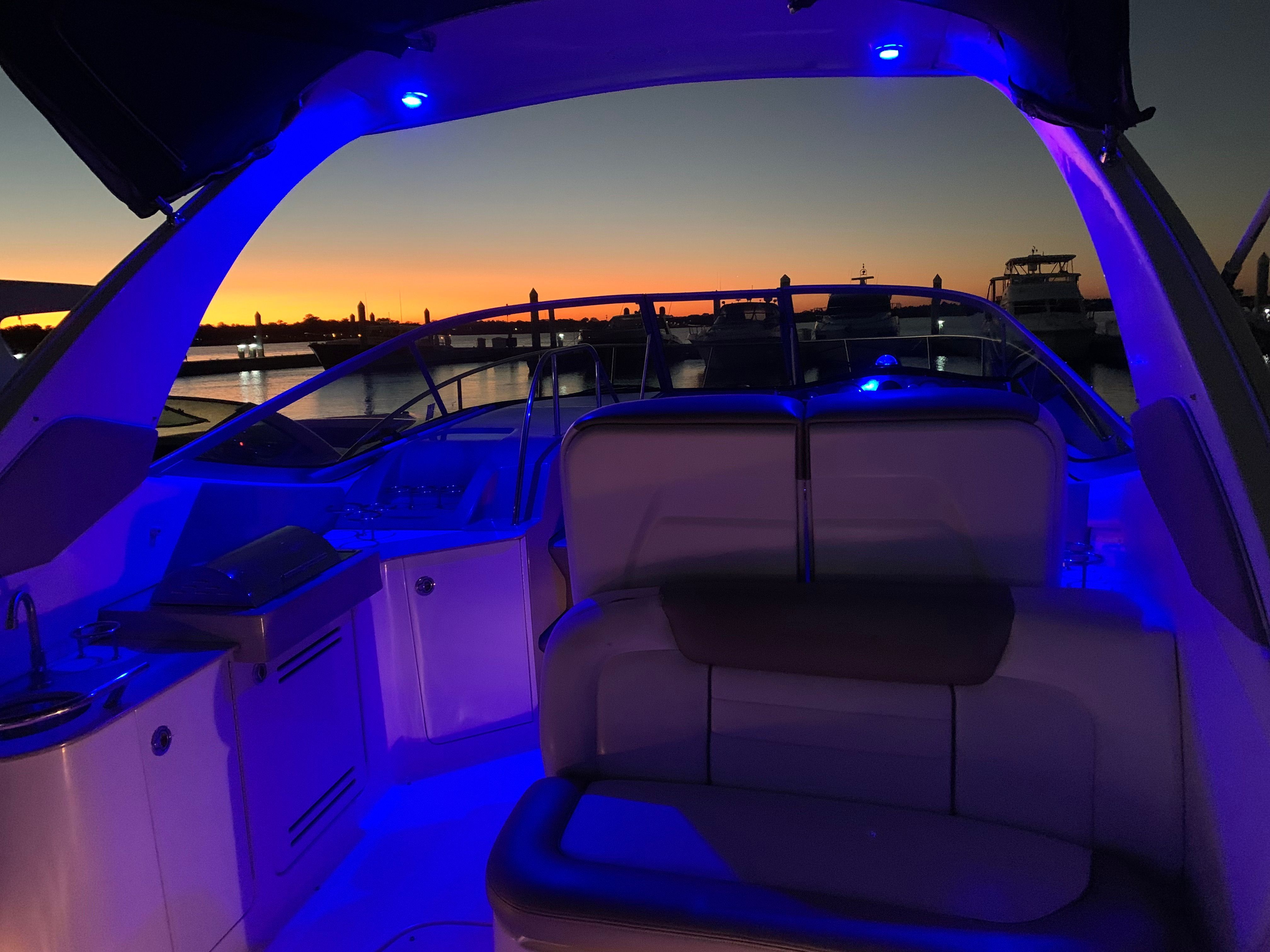 2007 Sea Ray Sundancer 310 at sunset with blue lighting.