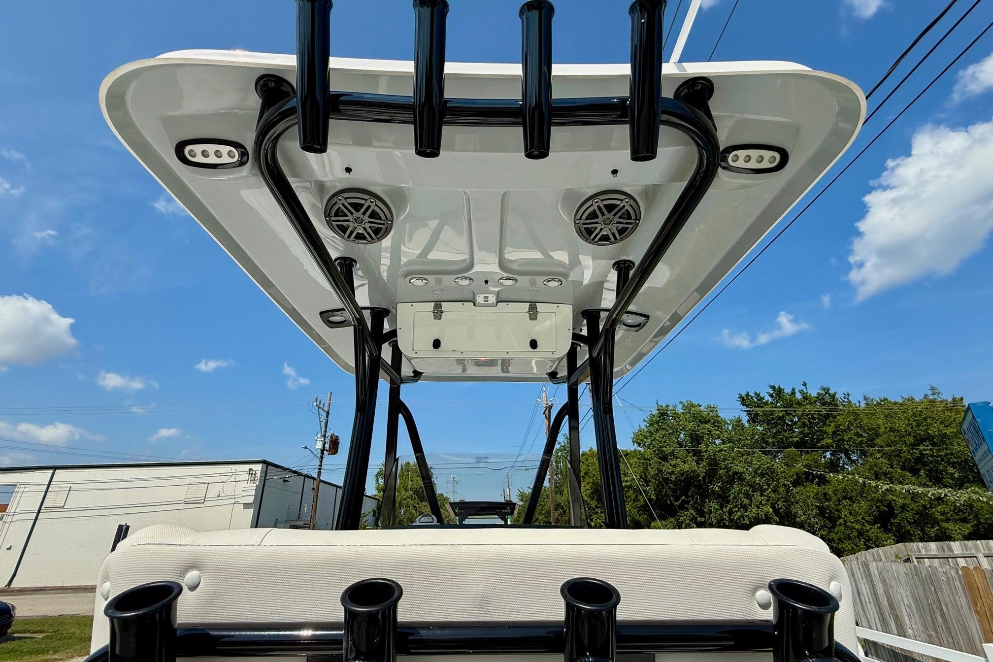 2026 Sea Hunt Ultra 229 boat with T-top and rod holders under a clear sky.