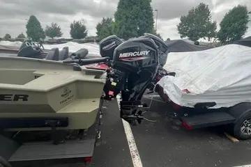 2026 Tracker Grizzly 1650 T Prairie Wings Edition boat with Mercury outboard motor in parking lot.