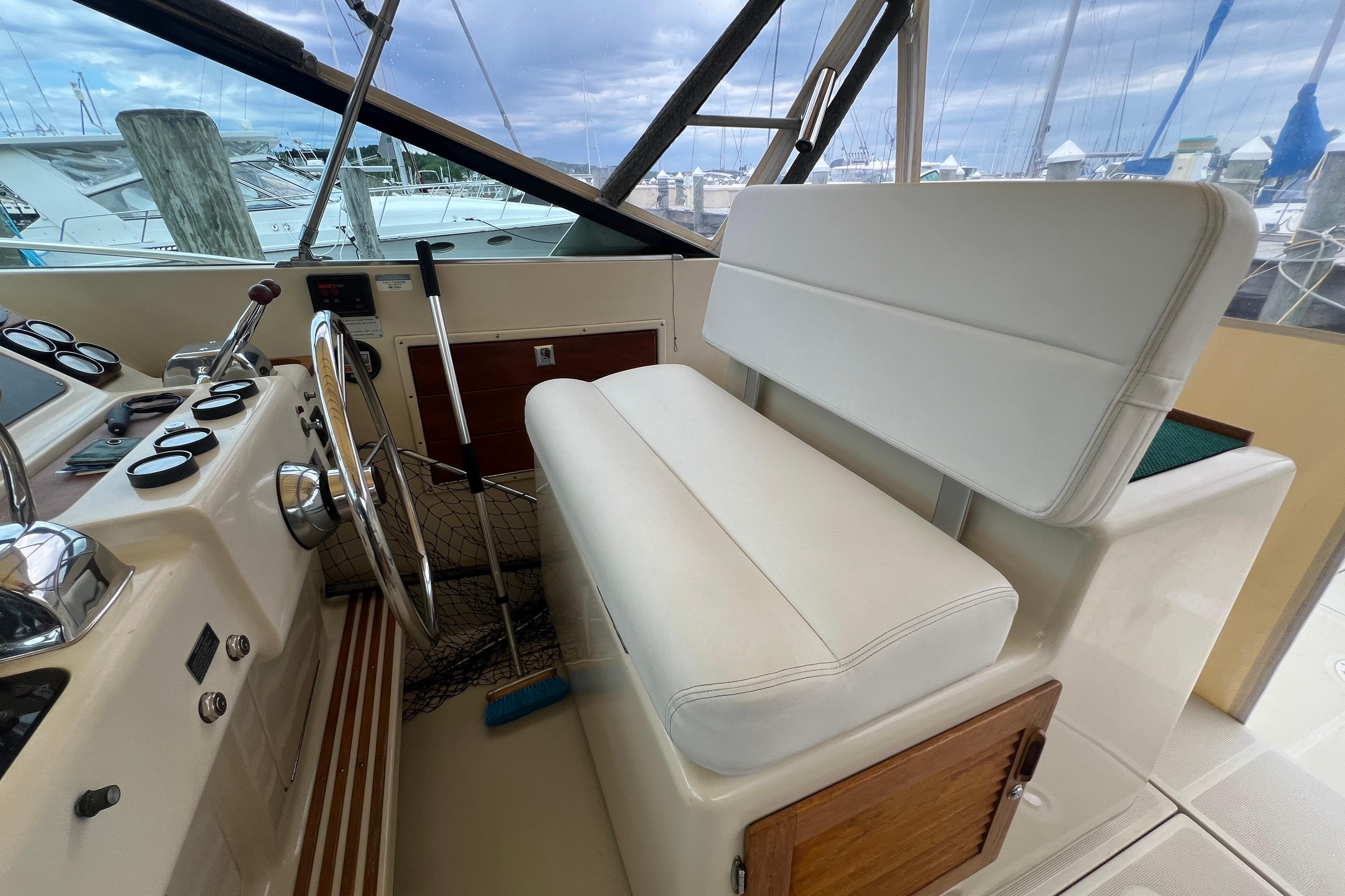 1985 Tiara 36 OPEN boat interior with steering wheel and white seating.