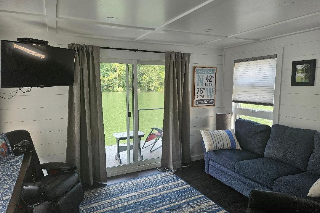 Interior of 2021 East Coast Houseboats Freedom 40, featuring cozy seating and scenic water view.
