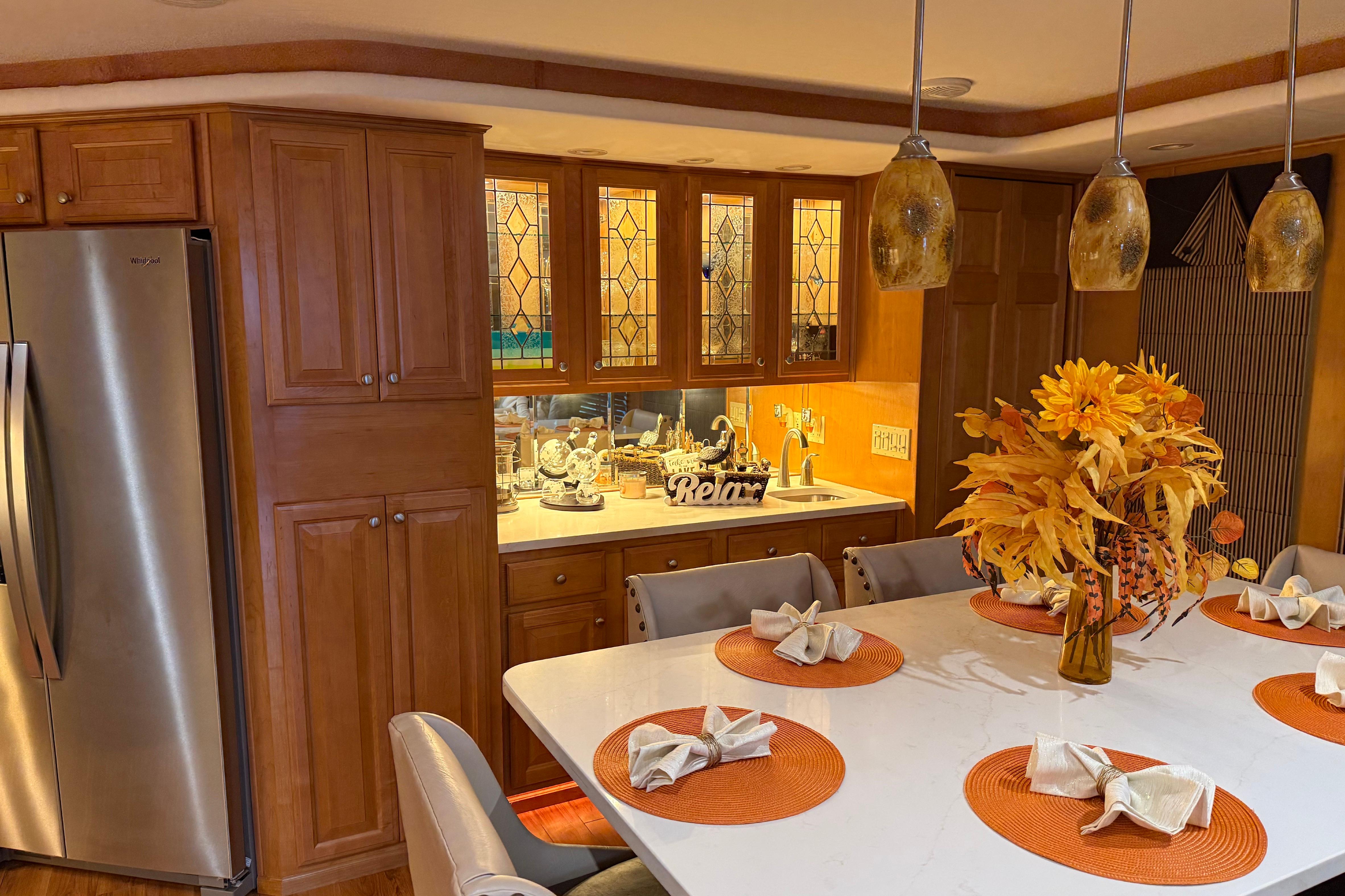 Luxurious kitchen interior with autumn decor, featuring wooden cabinets and modern lighting in a 2001 Sharpe model.