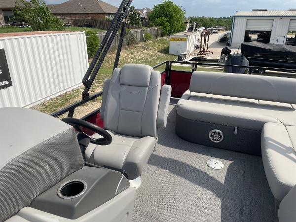 2023 Regency 250DL3 pontoon boat interior with gray seating and steering console.