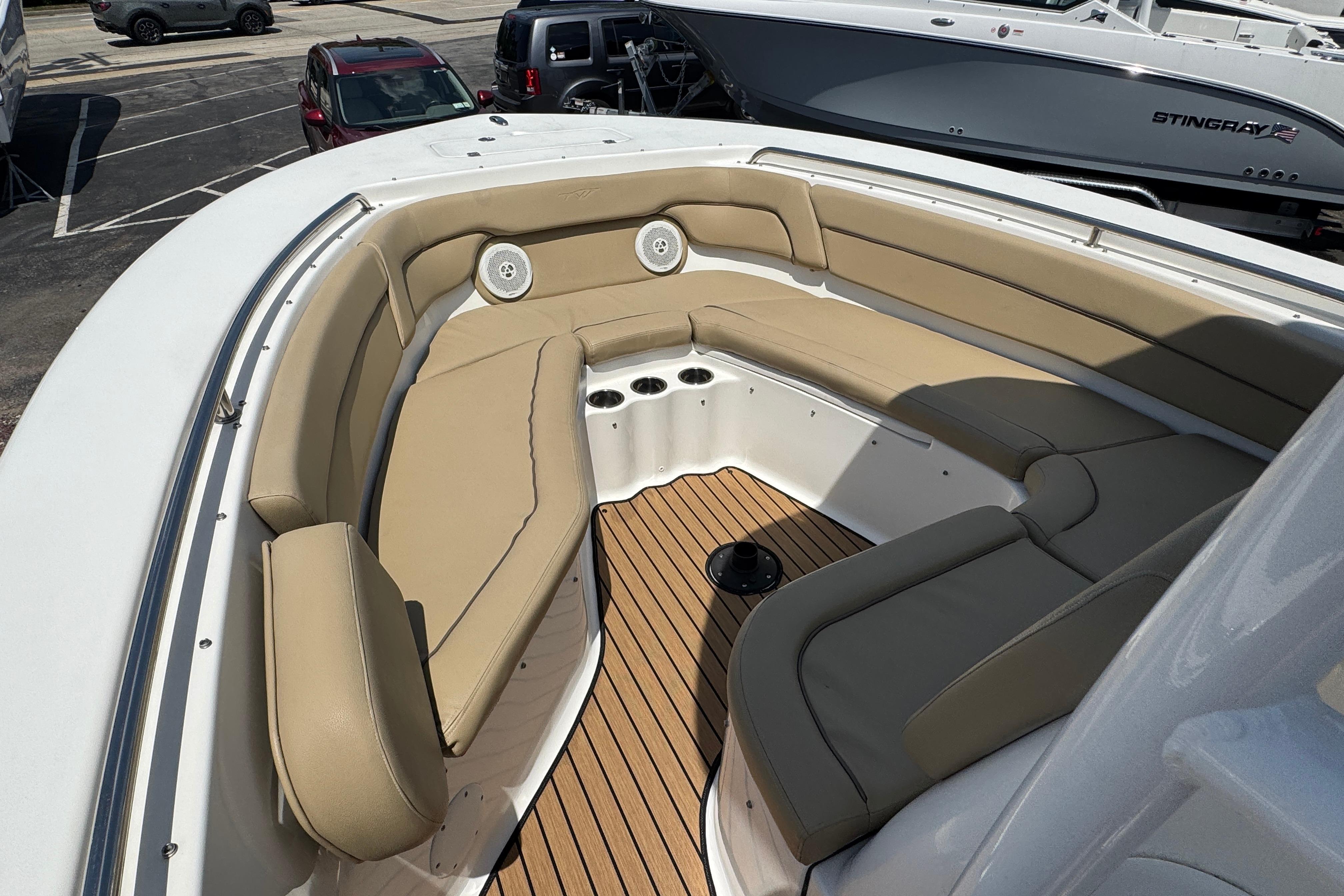 2016 Tidewater 230 LXF boat with tan seating and wood deck in a marina.