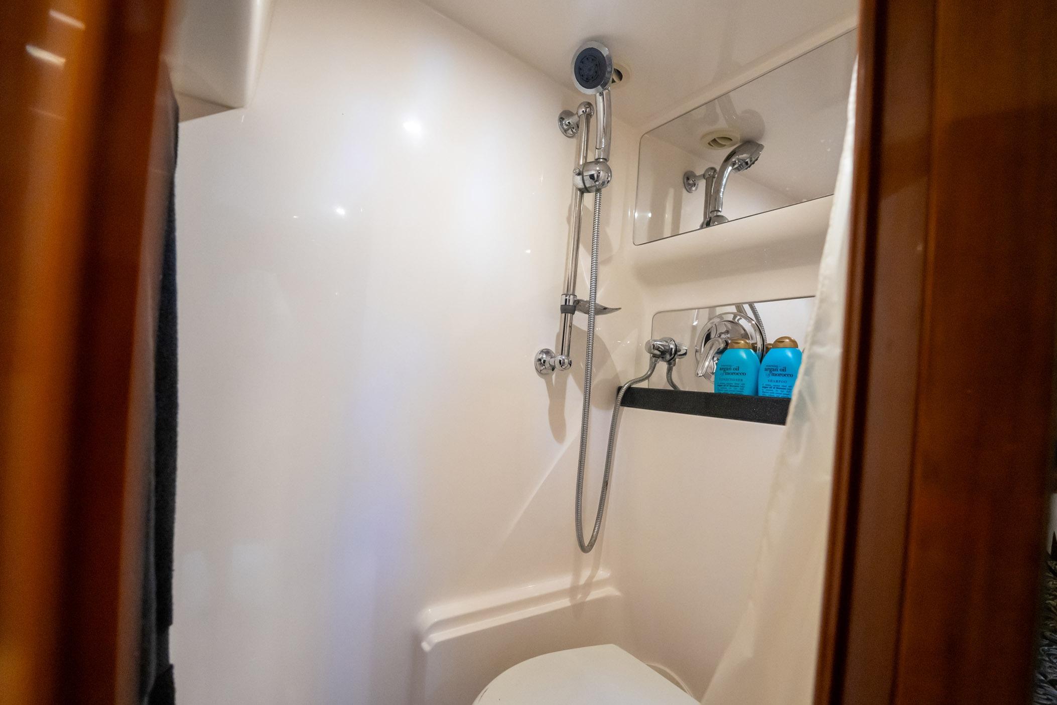 Luxurious bathroom in 2008 Regal Commodore 4460 yacht with shower and toiletries.