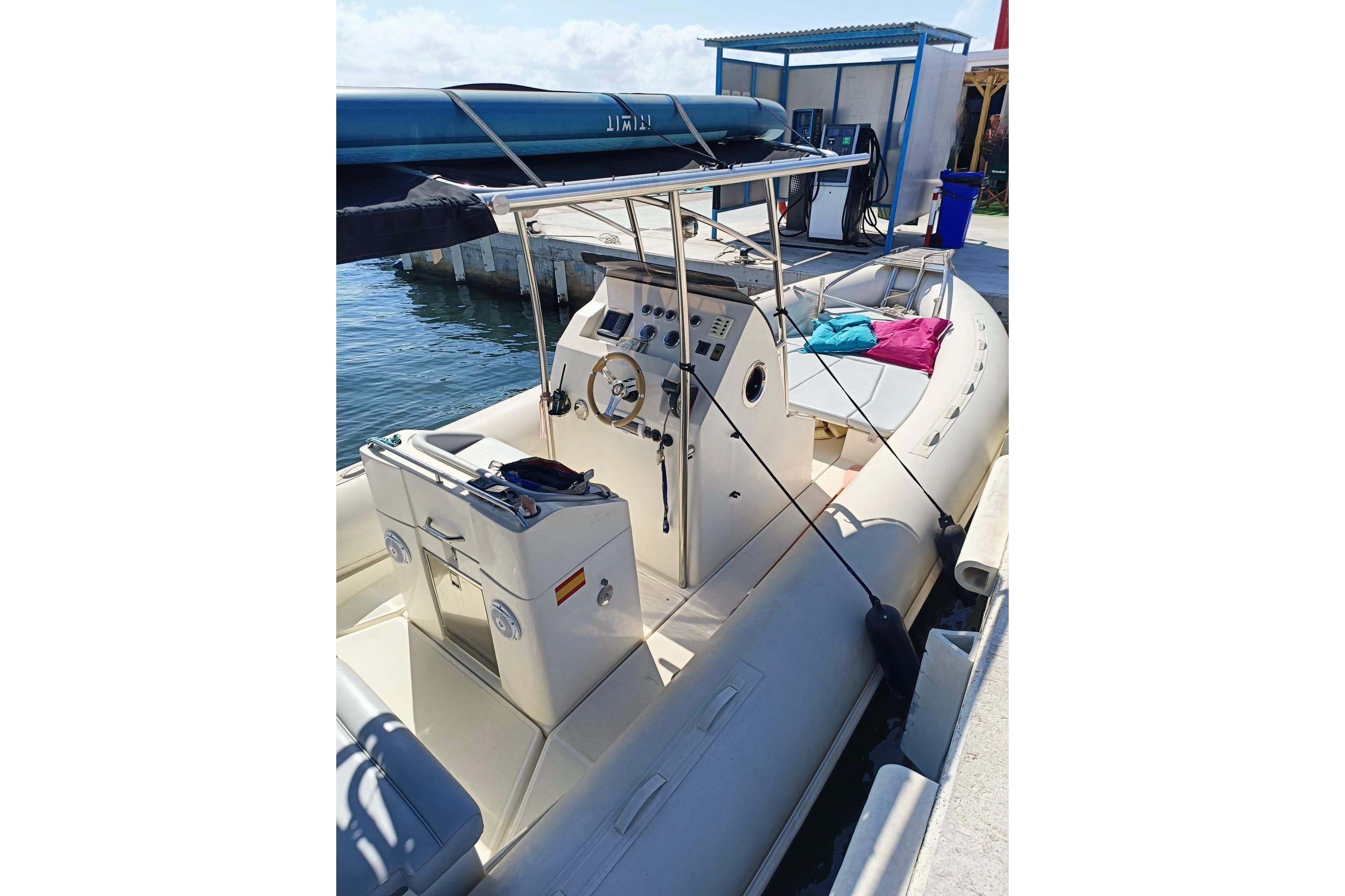 Inflatable boat docked at marina with control console and seating area.