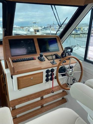 Helm station of 2025 Back Cove 39O boat with dual screens and wooden accents.