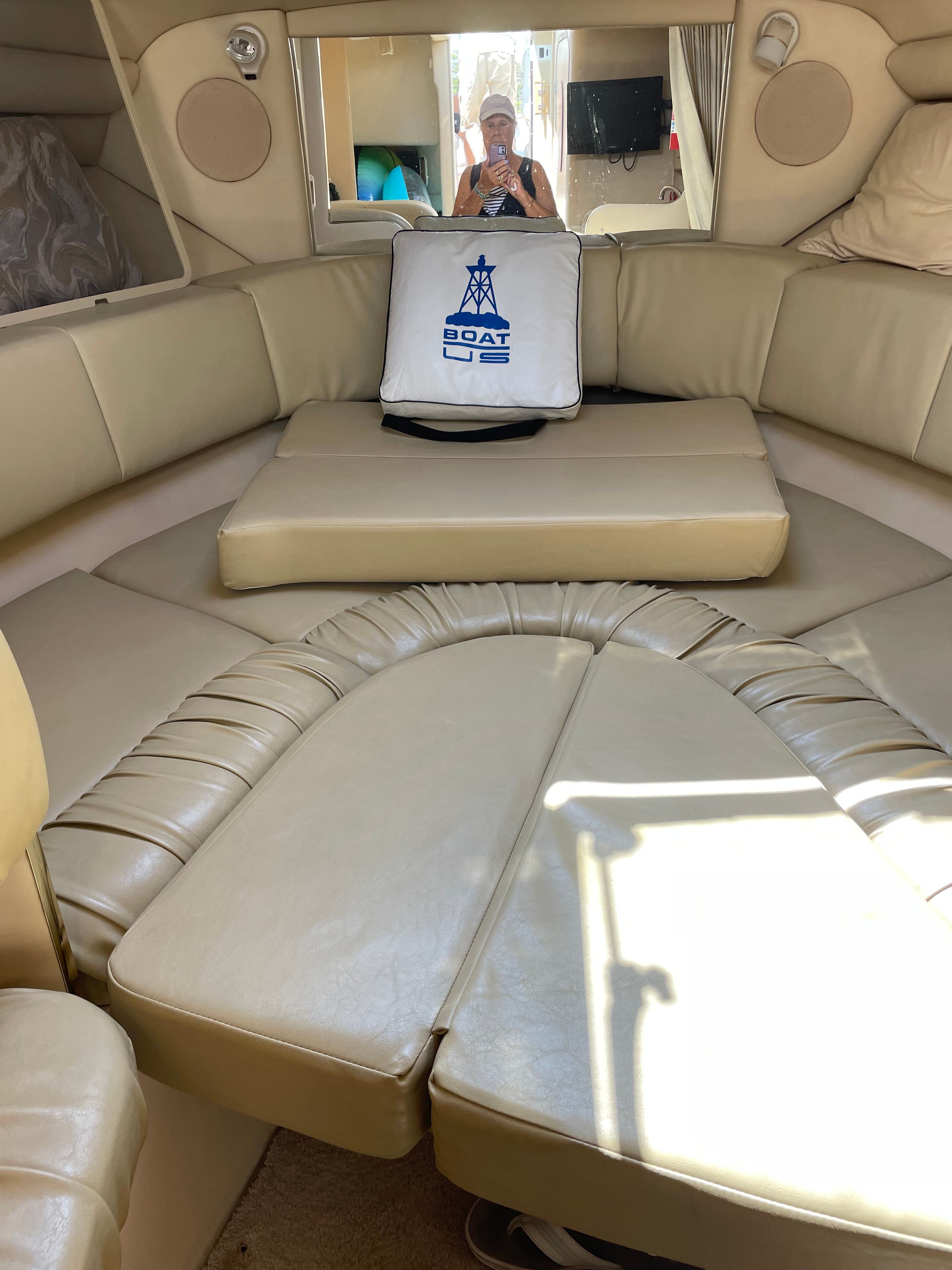 Interior of the 1998 Sea Ray 270 Sundancer with beige upholstery and a cushion.