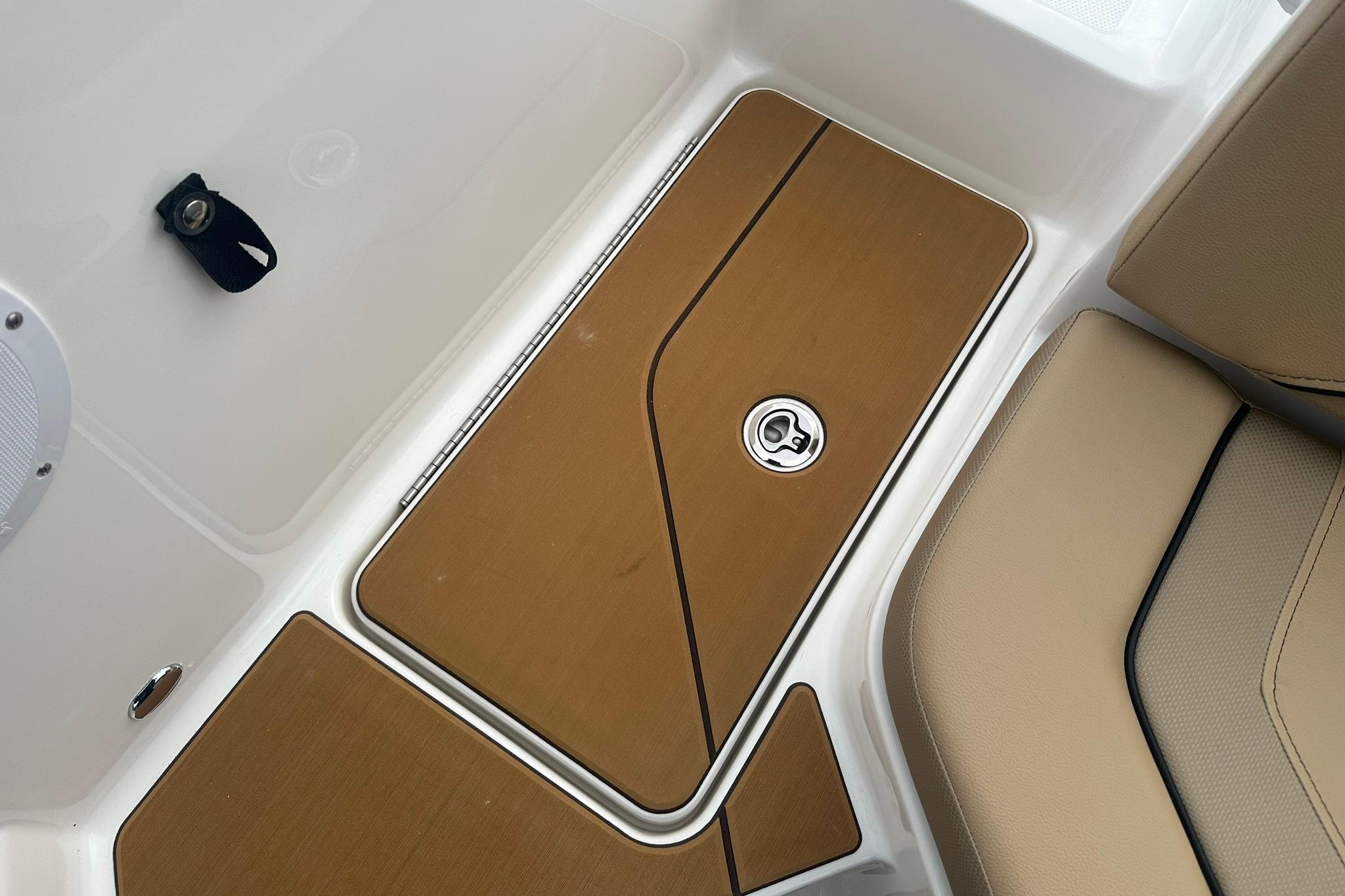 2026 Bayliner V20 boat interior with tan seating and storage compartment.