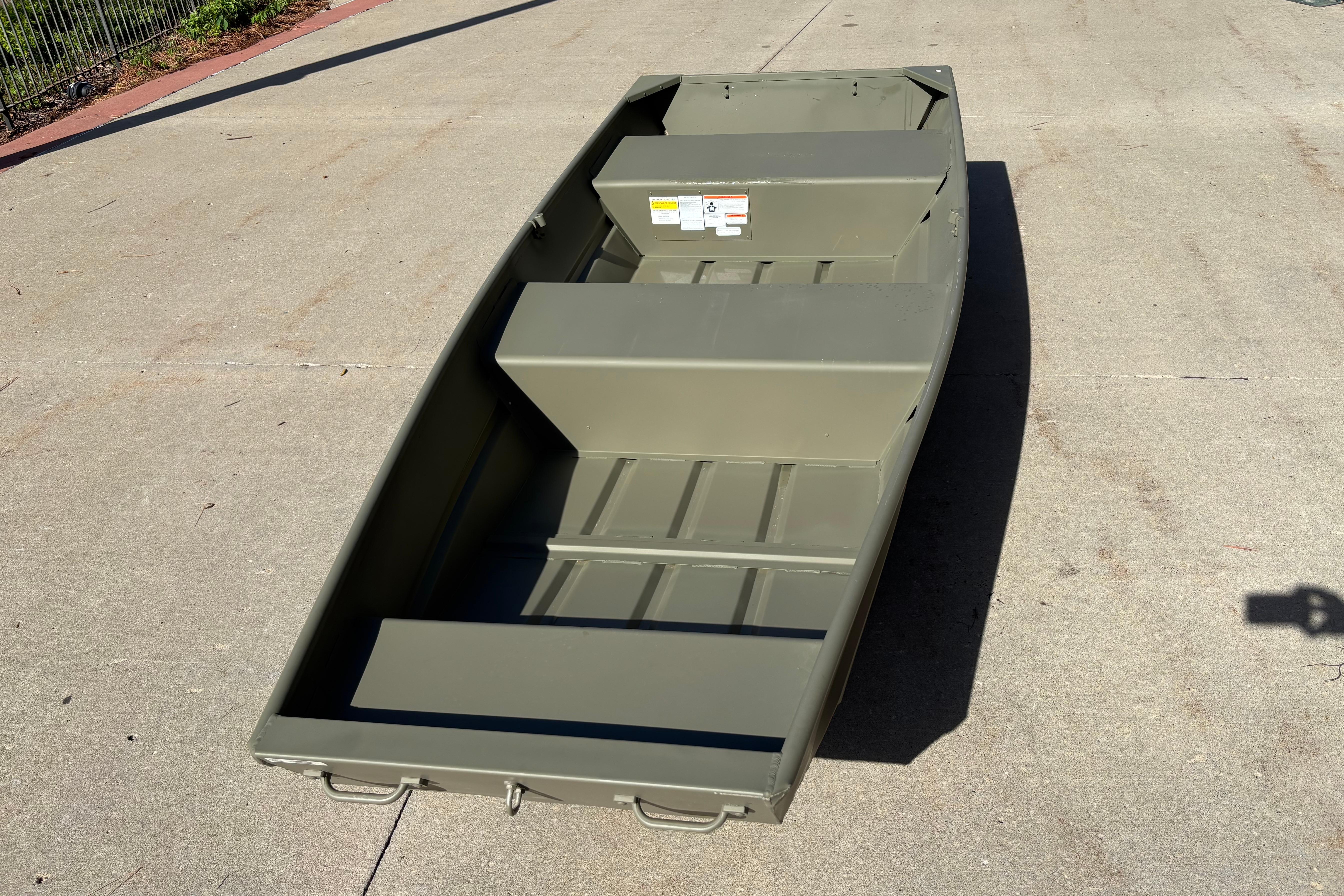 2026 Tracker Grizzly 12 Jon boat on concrete surface, showcasing its sturdy design.