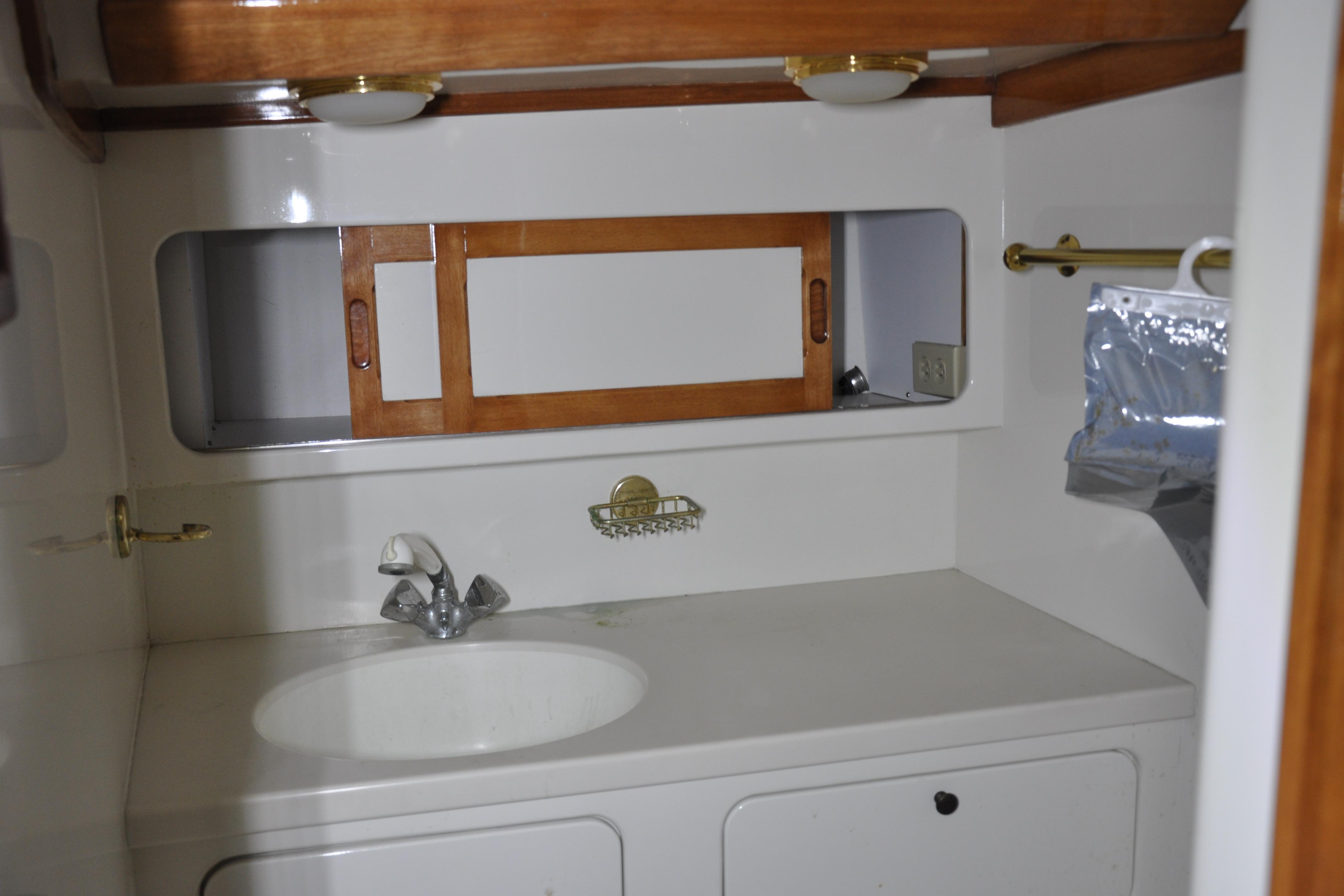 1970 Hinckley Bermuda 40 yacht bathroom with sink, wooden accents, and storage.