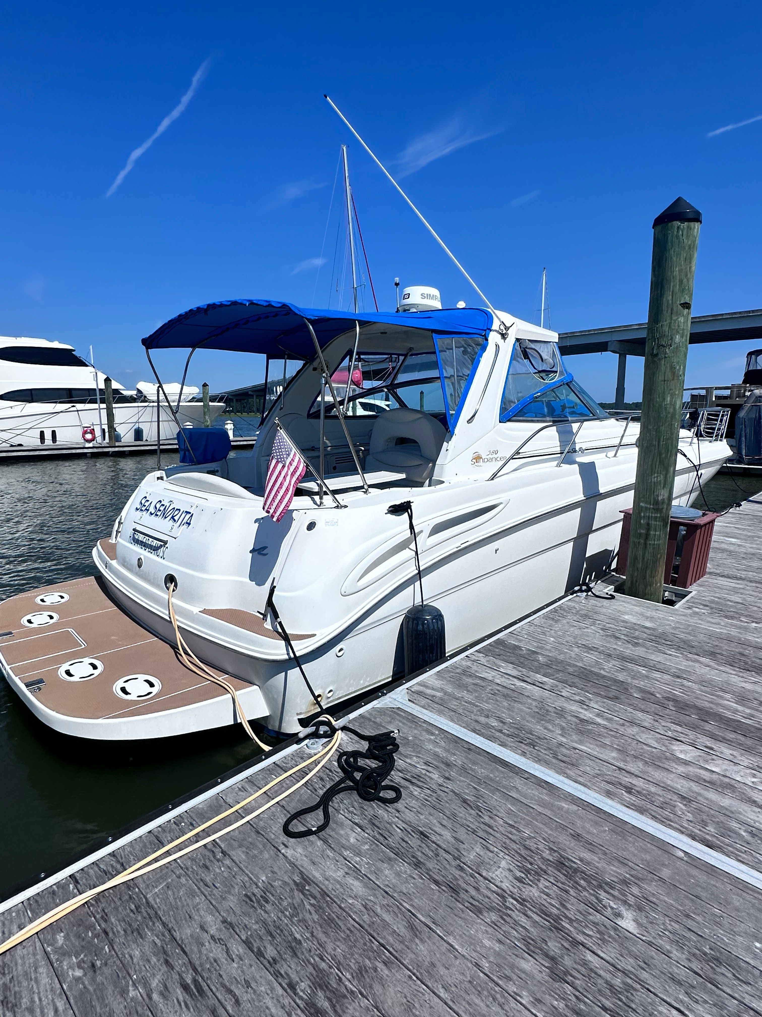 2000 Sea Ray 380 Sundancer docked at marina under clear blue sky.