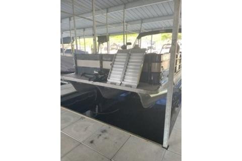 2023 PlayCraft 27 Infinity boat docked under a covered marina.