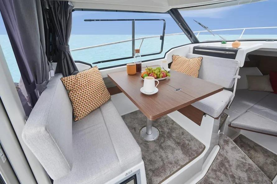 Interior of 2026 Jeanneau NC 795 Series 2 boat with dining area and sea view.