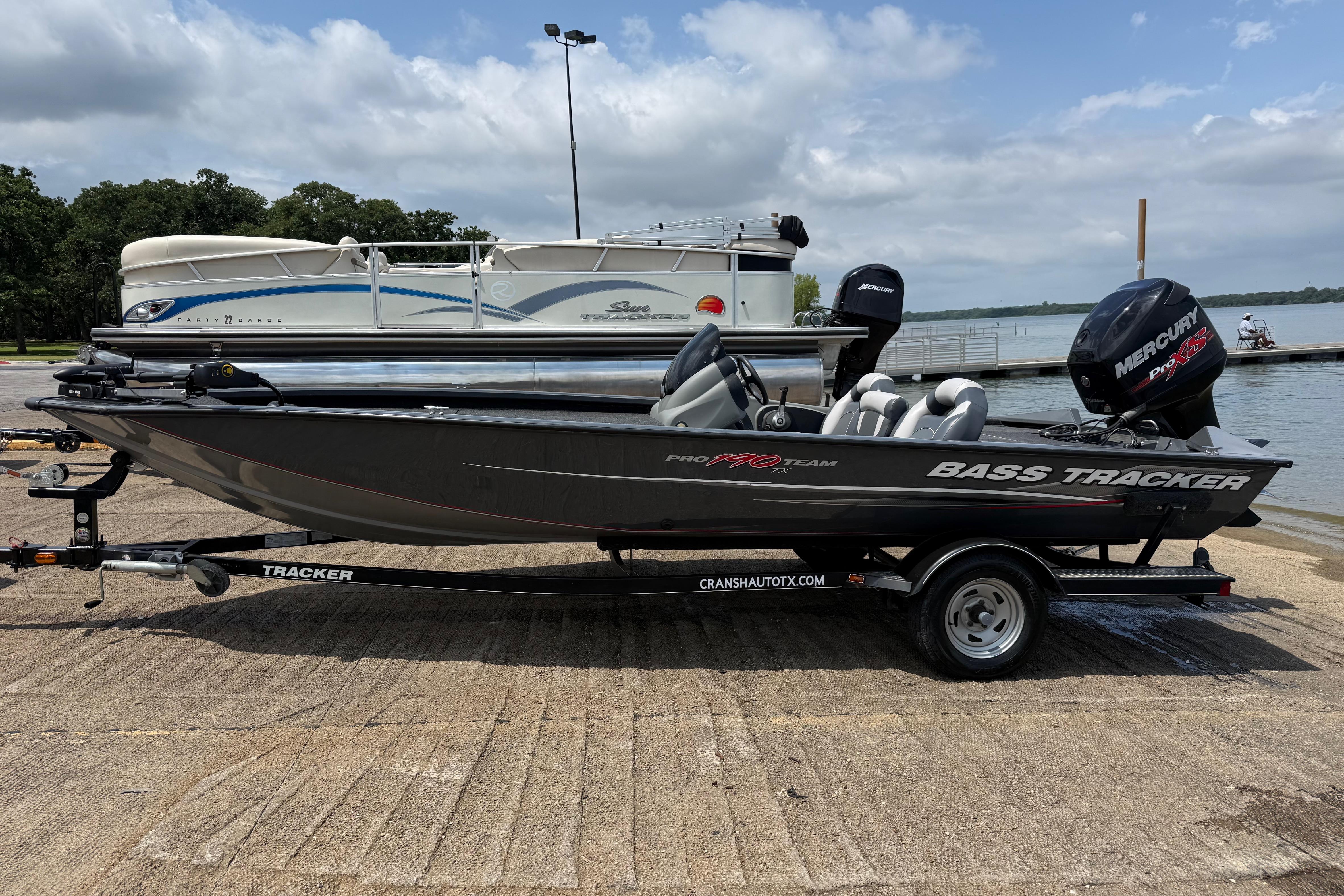 2015 Tracker Pro Team 190 TX bass boat on trailer by a lake.