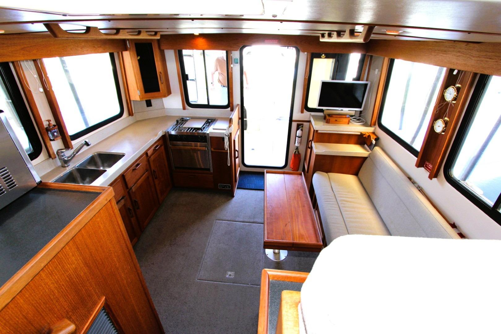 Interior of 2002 Nordic Tug 37, featuring kitchen, seating, and entertainment area.