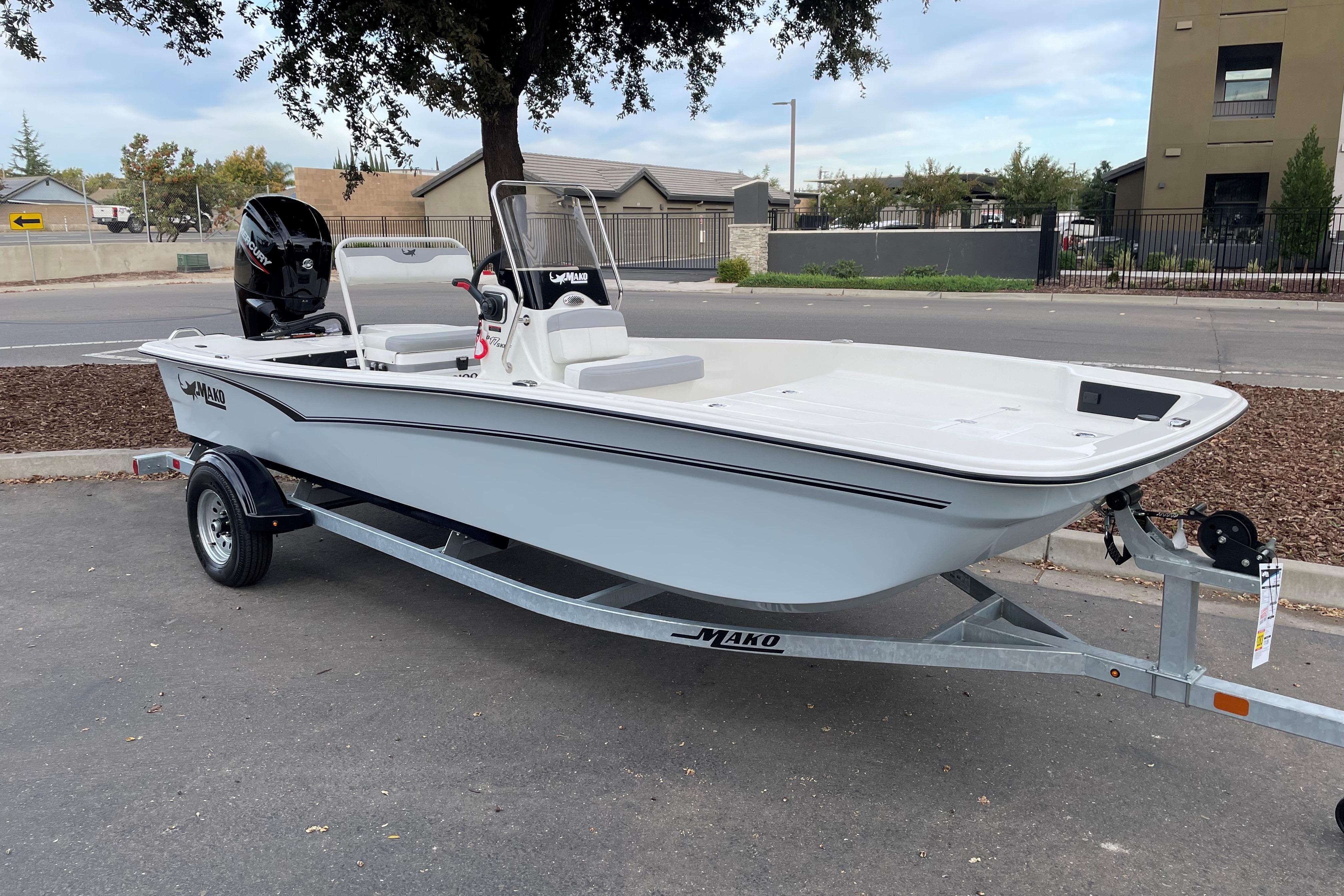 2025 Mako Pro Skiff 17 CC boat on trailer, parked outdoors.