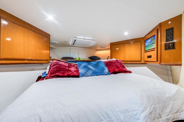 Luxurious cabin interior of 1999 Viking 47 Convertible yacht with cozy bedding.