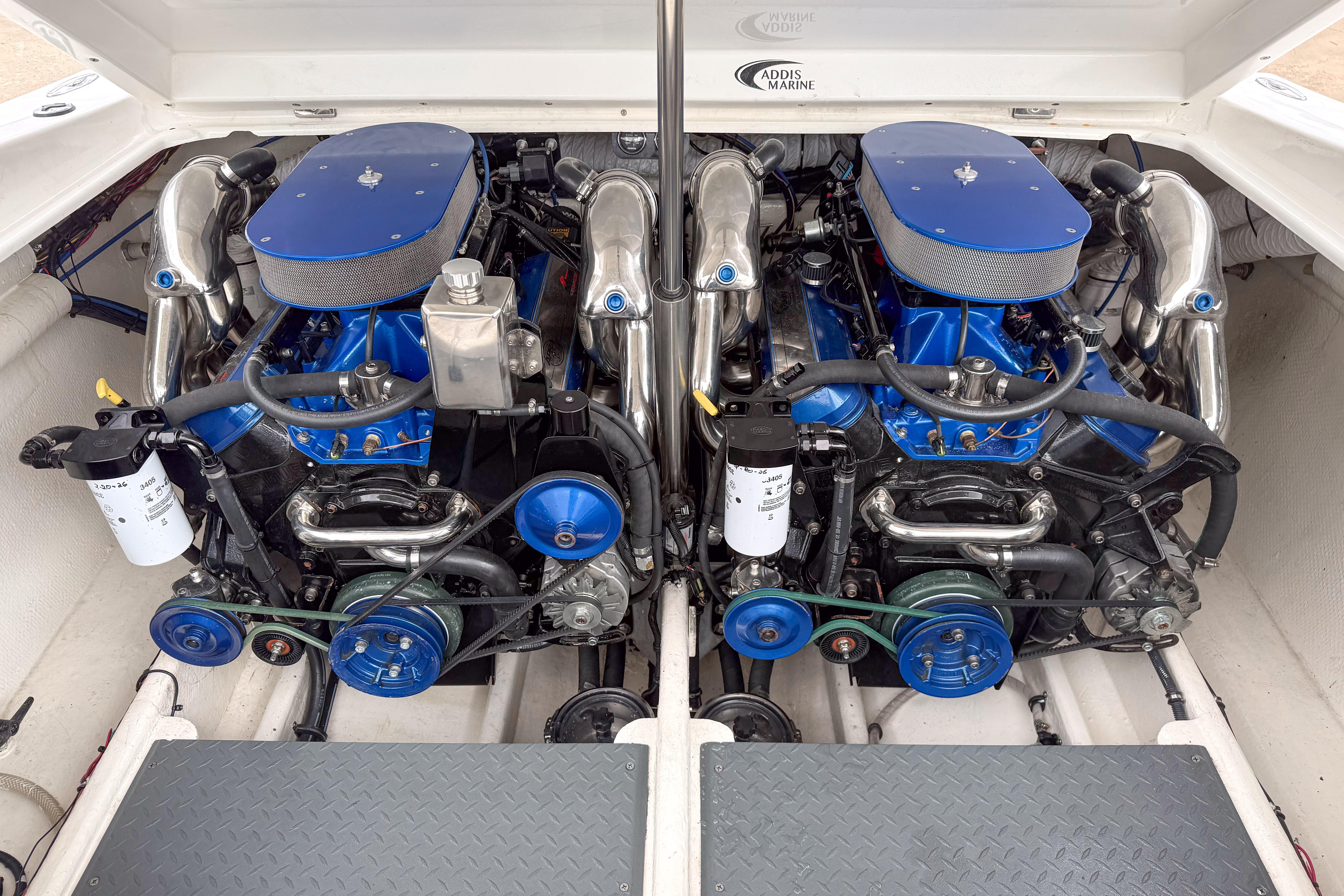 Twin engines in a 2002 Active Thunder 37 boat, showcasing blue and chrome components.