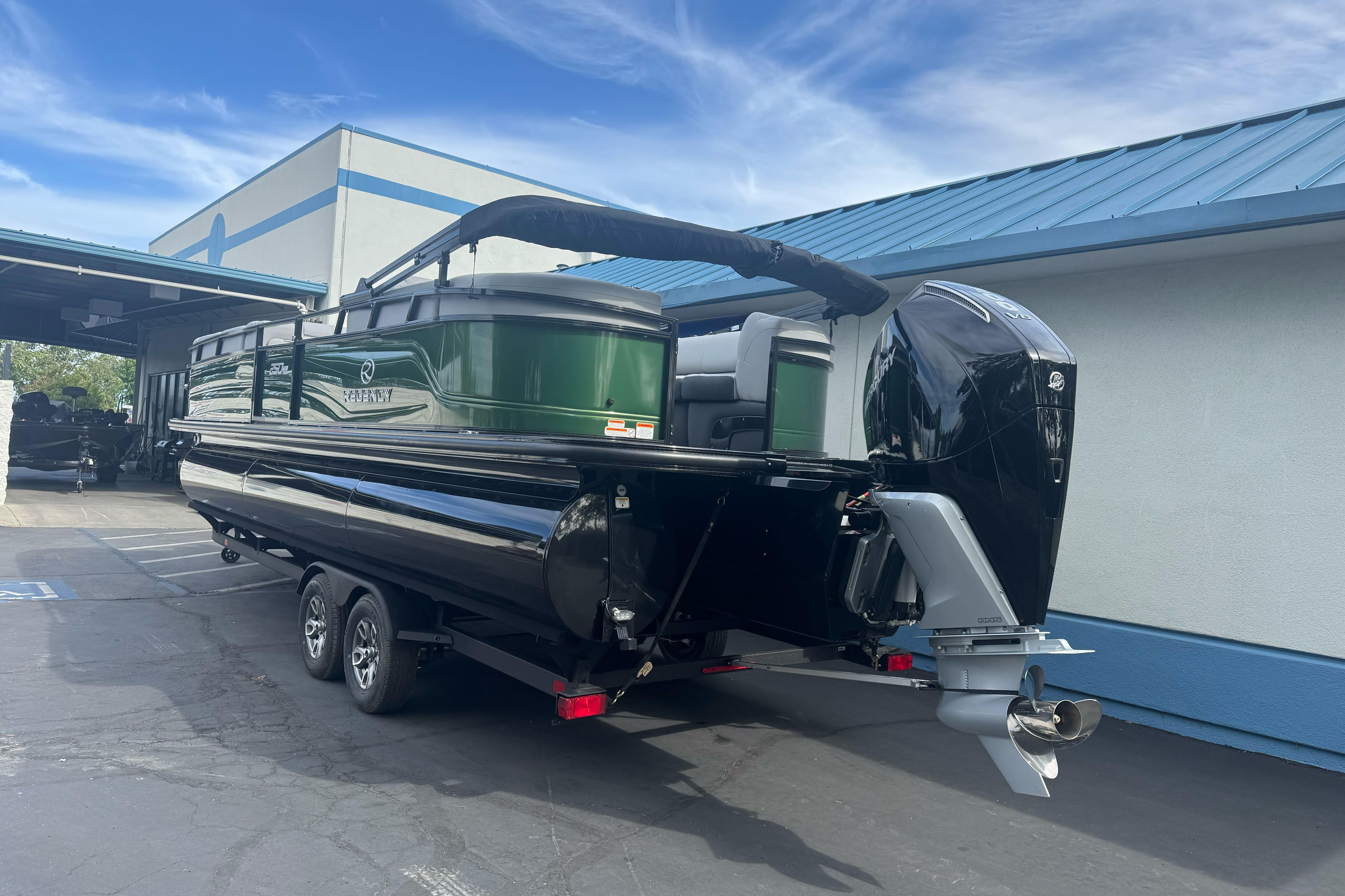 2026 Regency 250 DL pontoon boat with outboard motor on trailer.