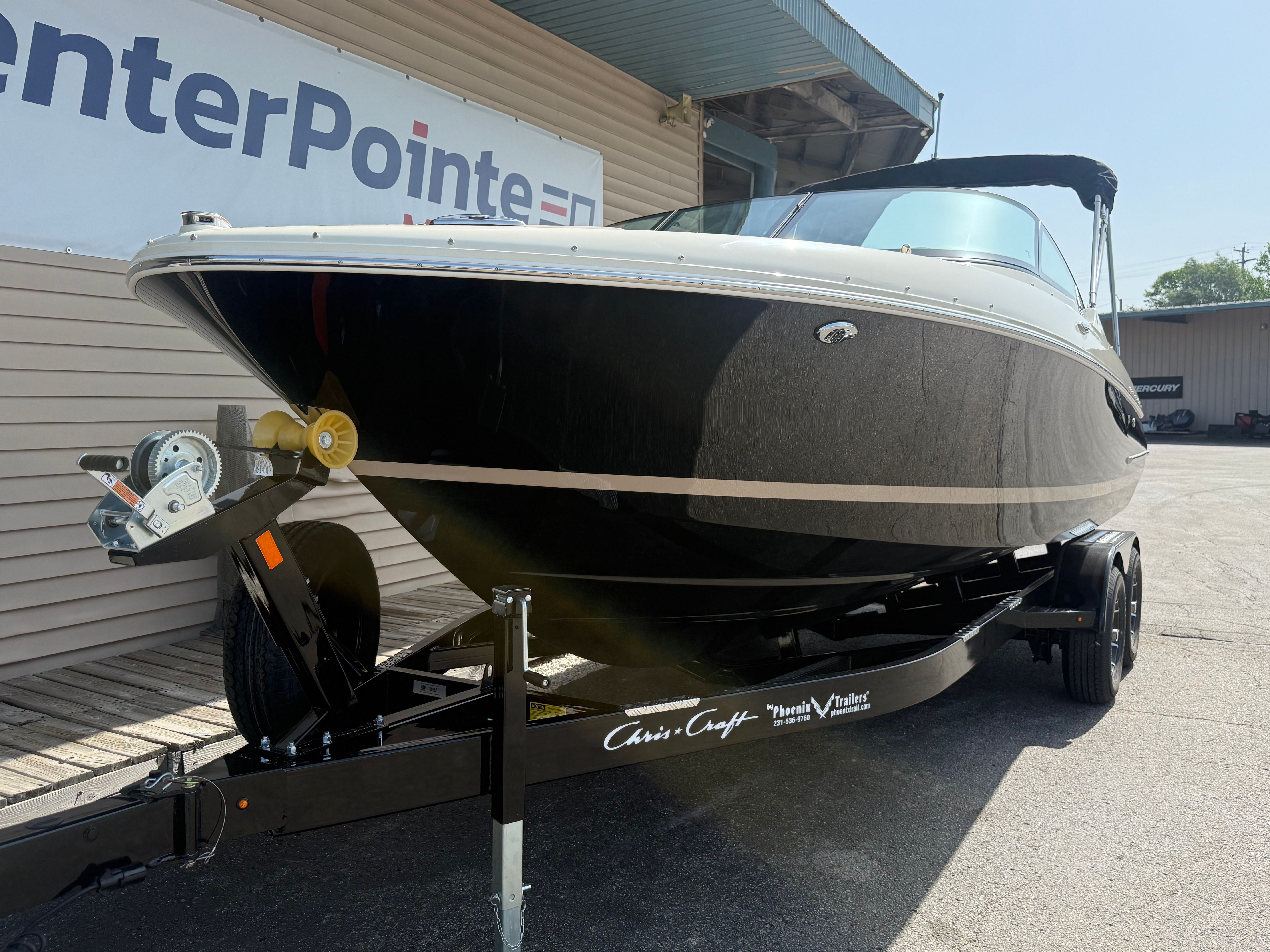 A 2027 Chris-Craft Sportster 25 on a trailer in front of a building.